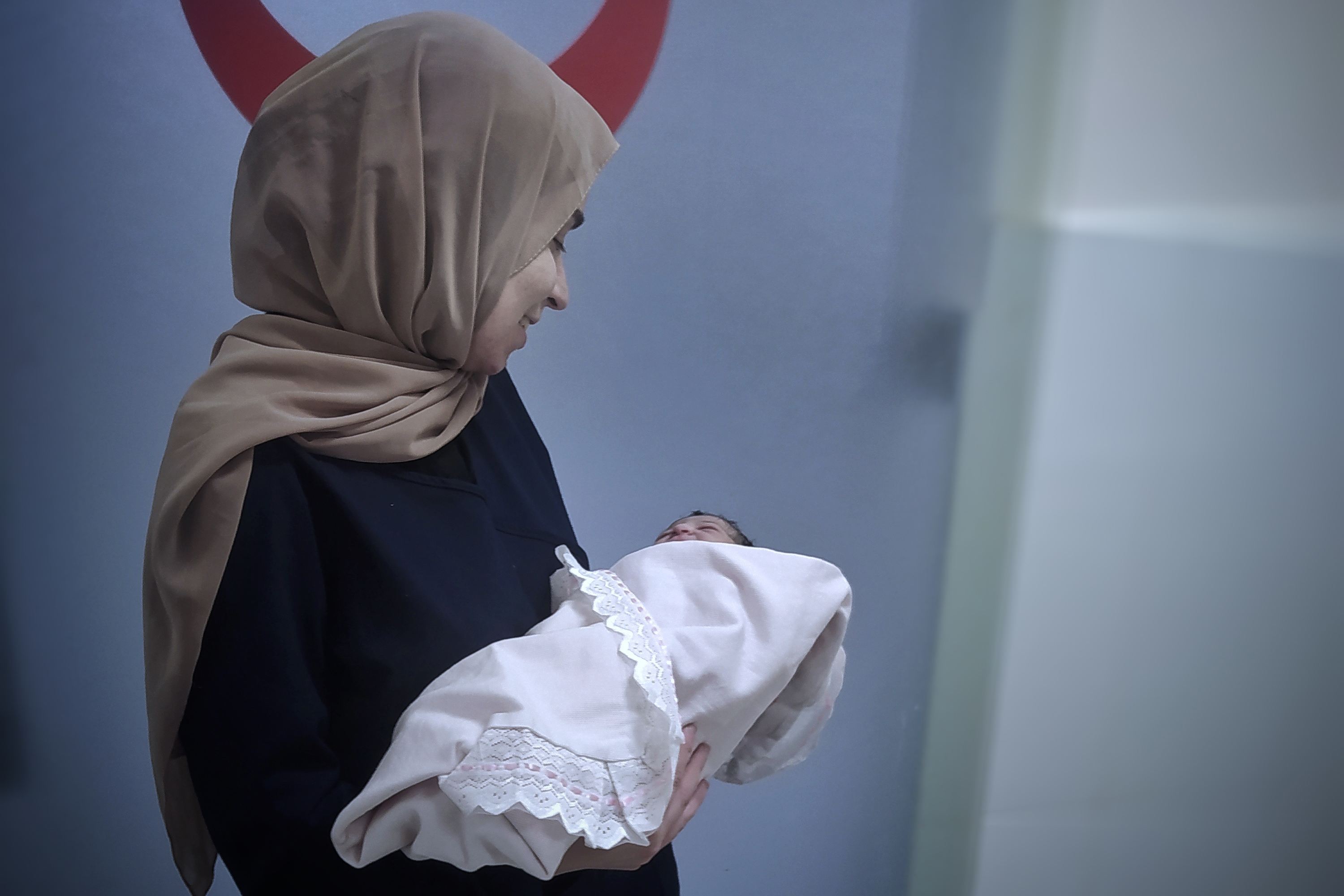 Nada Almadhoun holds a newborn she helped deliver on July 2.