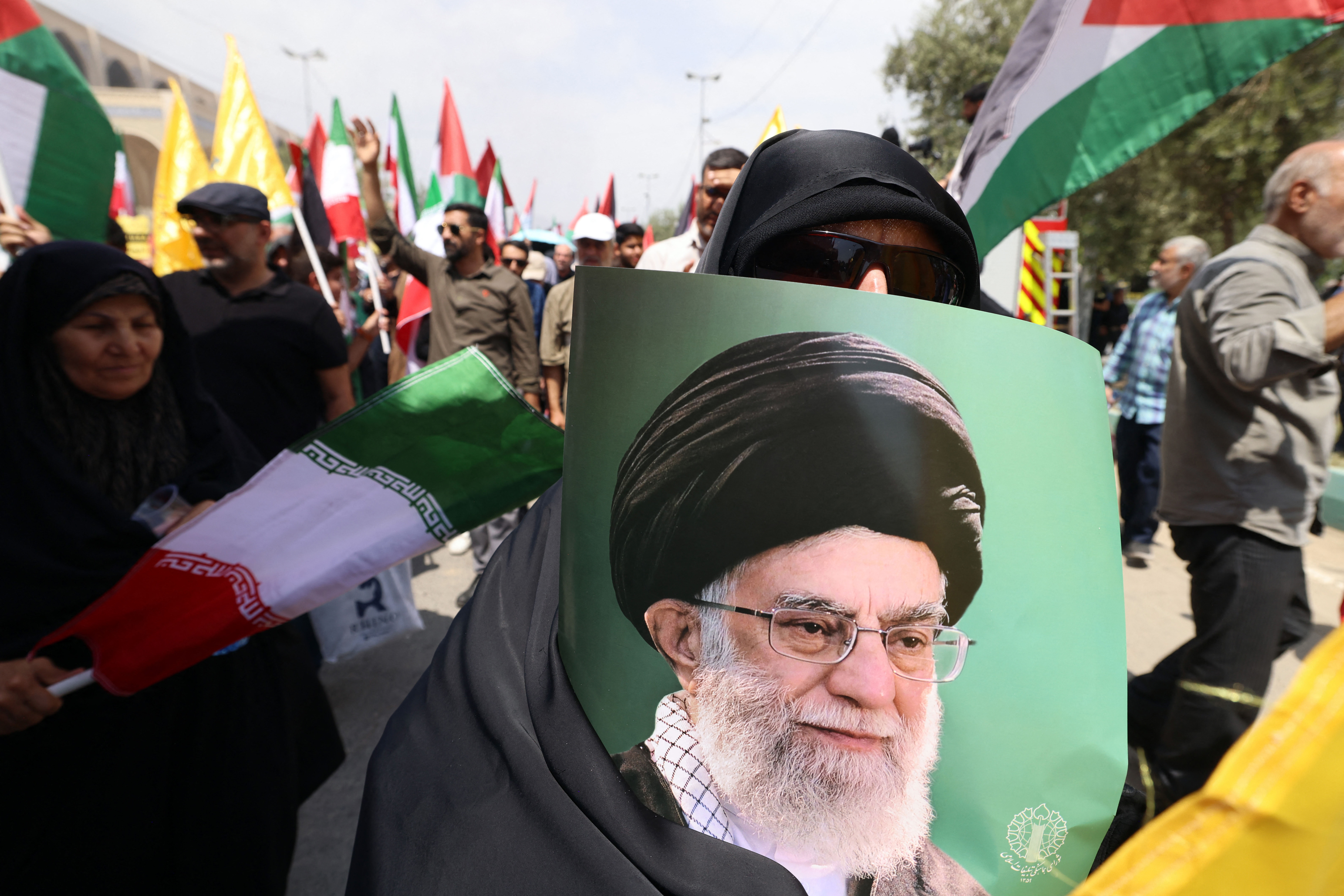 TOPSHOT - A demonstrator carries a portrait of Iran's Supreme Leader Ayatollah Ali Khamenei during a rally in solidarity with Palestinians and in condemnation of Israel and the US, after Friday prayers in Tehran, on July 25, 2025.