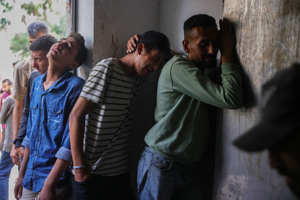 Palestinians mourn outside the morgue where bodies of people killed a day earlier while waiting for aid were brought, at the Al-Shifa hospital morgue in Gaza City on July 31, 2025. [Bashar Taleb/AFP]