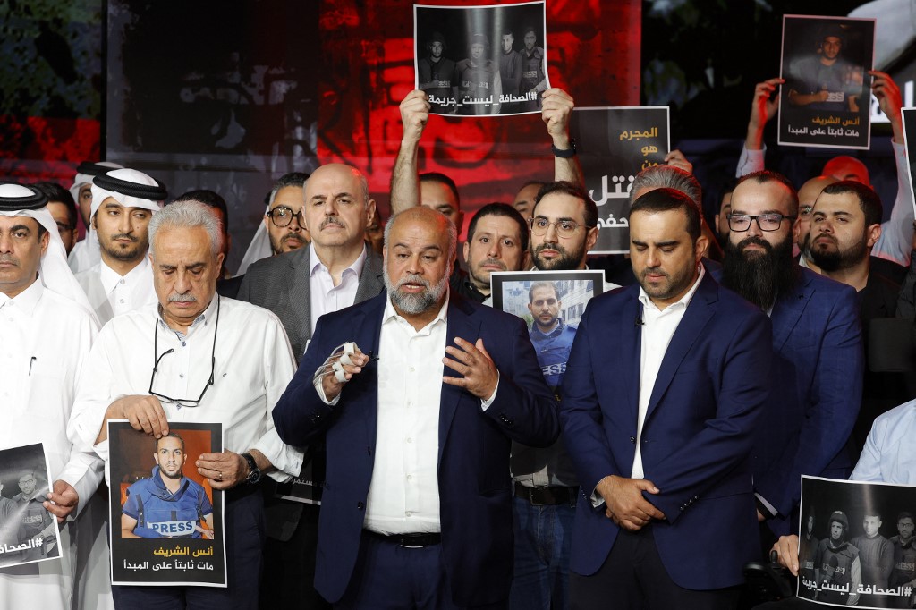 Wael Al-Dahdouh (C), Al Jazeera's bureau chief in Gaza, delivers a statement during a moment of silence to honour five of Al Jazeera staff members, killed in an overnight Israeli strike in Gaza City, at the networks' headquarters in Doha on August 11, 2025. [Karim Jaafar/AFP]