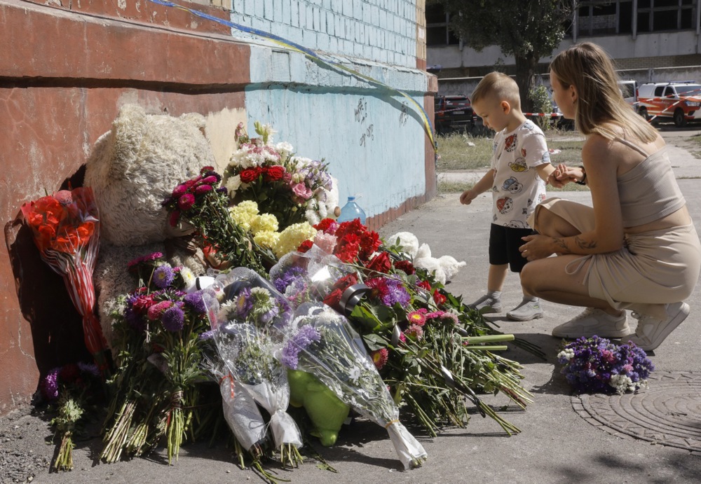 epa12333748 Ukrainians bring flowers and toys at the site of a Russian strike the previous day hit a five-storey residential building in Kyiv, Ukraine, 29 August 2025, amid the ongoing Russian invasion. At least 23 people were killed, including four children, and 50 were injured in Kyiv when Russia launched an overnight attack over Ukraine, according to the State Emergency Service. EPA/SERGEY DOLZHENKO