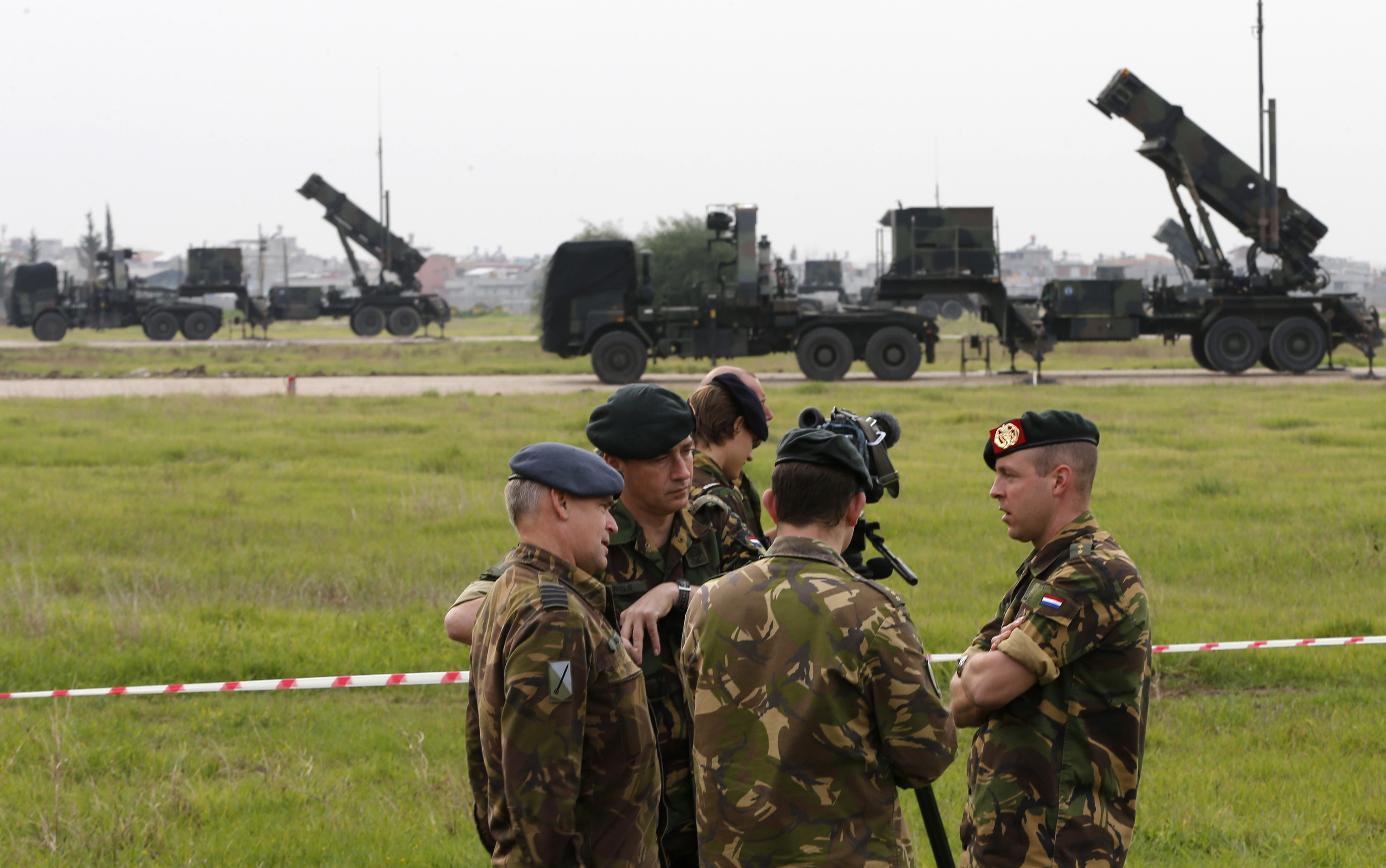 Dutch soldiers, with the Patriot system in the background, chat during media day at a military airbase in Adana, southern Turkey, January 26, 2013. The first of six Patriot missile batteries being sent by NATO countries to defend Turkey from possible attack from Syria went operational on Saturday. The United States, Germany and the Netherlands are each sending two batteries to Turkey and up to 400 soldiers to operate them after Ankara asked NATO for help. The Patriots are capable of shooting down hostile missiles in mid-air. REUTERS/Murad Sezer (TURKEY - Tags: POLITICS MILITARY)