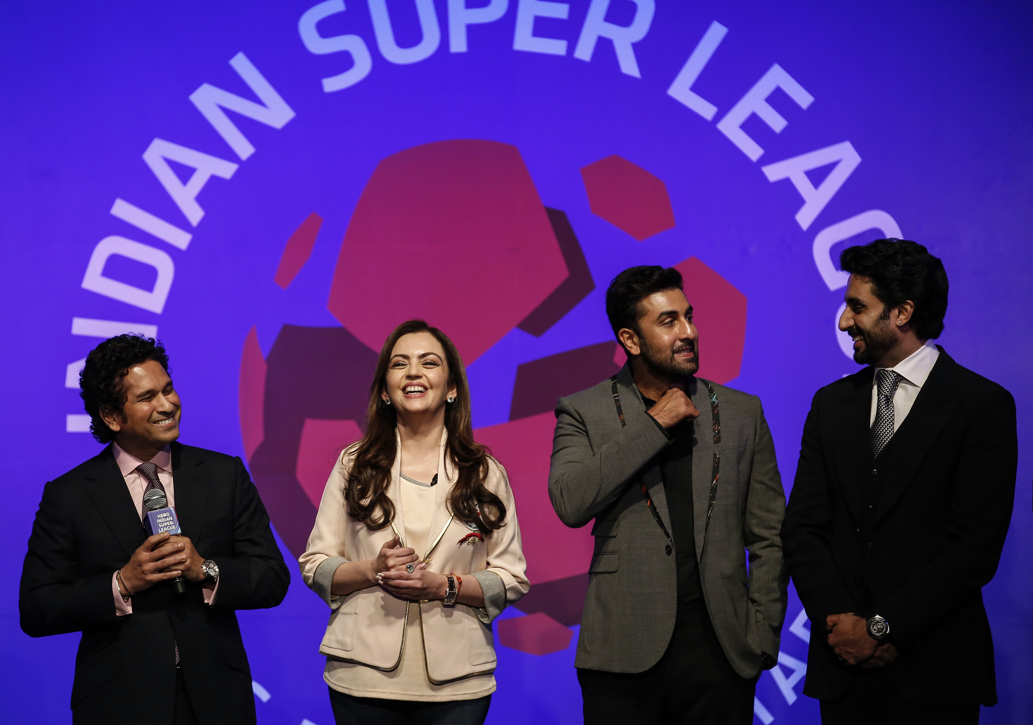 Bollywood actors and co-owners of football clubs, Abhishek Bachhan (R) and Ranbir Kapoor (2nd R), and Nita Ambani, businesswoman and promoter of the Indian Super League, react as retired cricketer and co-owner of the Kerala Blasters Sachin Tendulkar (L) speaks during the emblem-unveiling ceremony of Indian Super League in Mumbai August 28, 2014