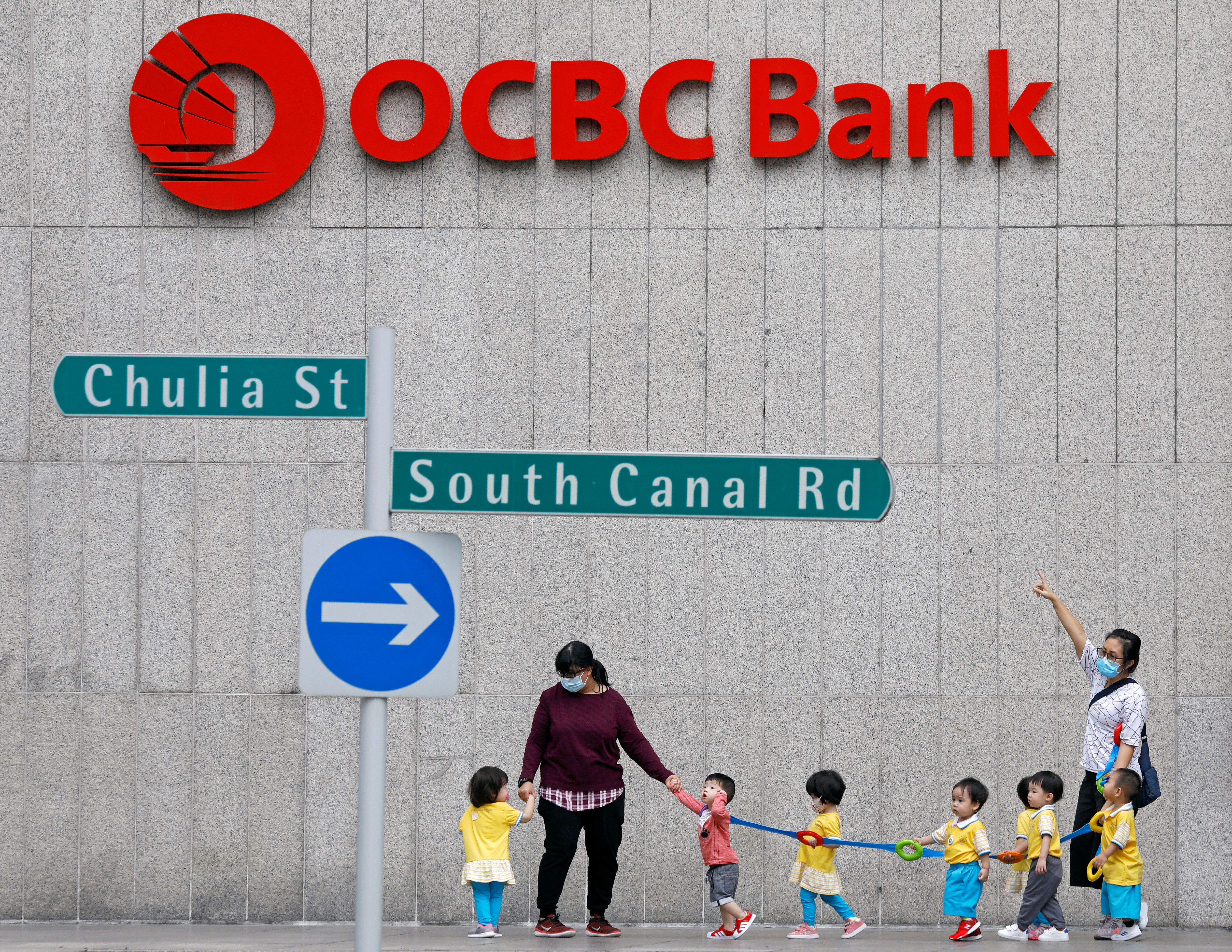Children pass by an OCBC bank branch in Singapore November 4, 2020. REUTERS/Edgar Su