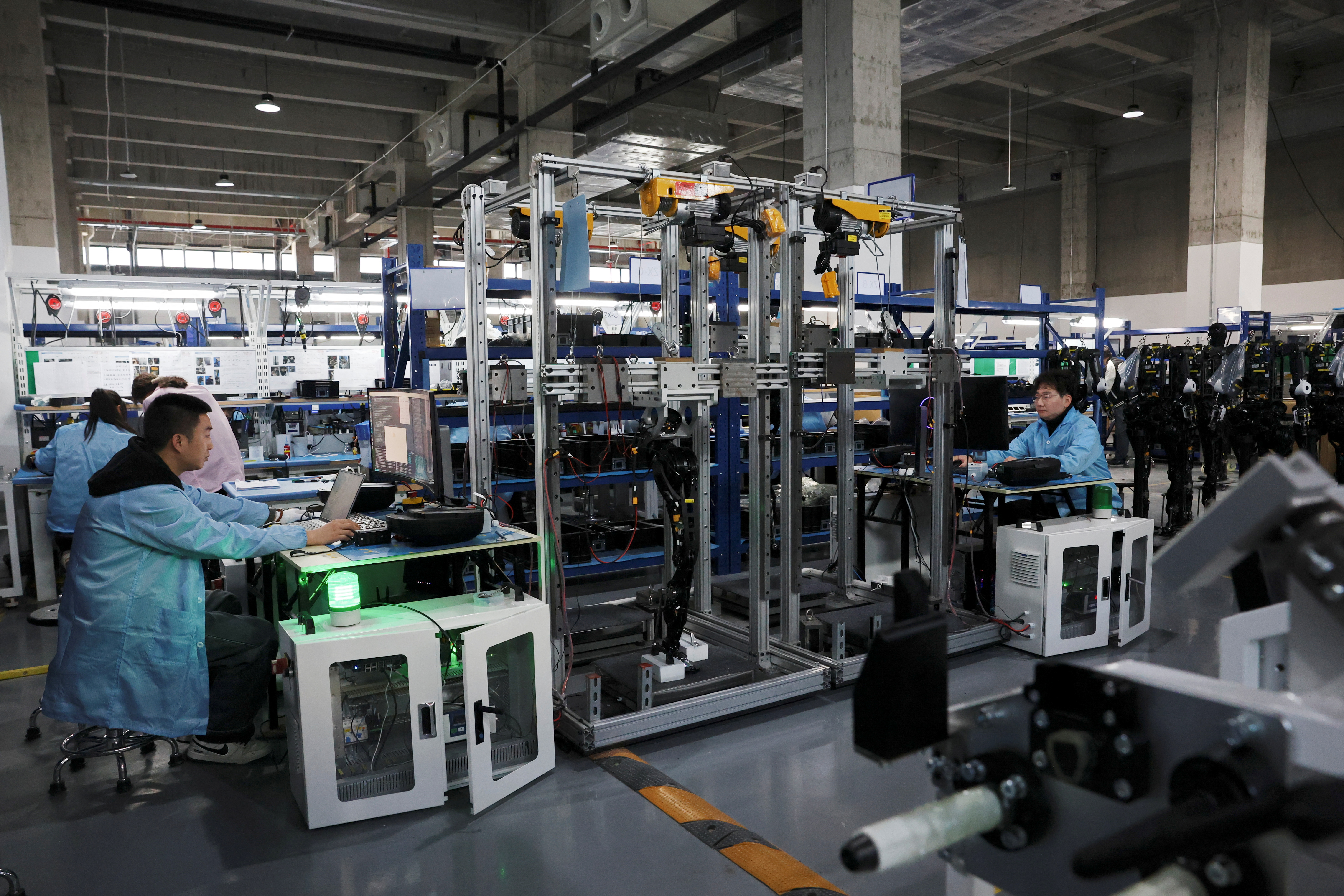 Employees work on the humanoid robot assembly line at the AgiBot factory in Shanghai, China March 20, 2025. REUTERS/Florence Lo