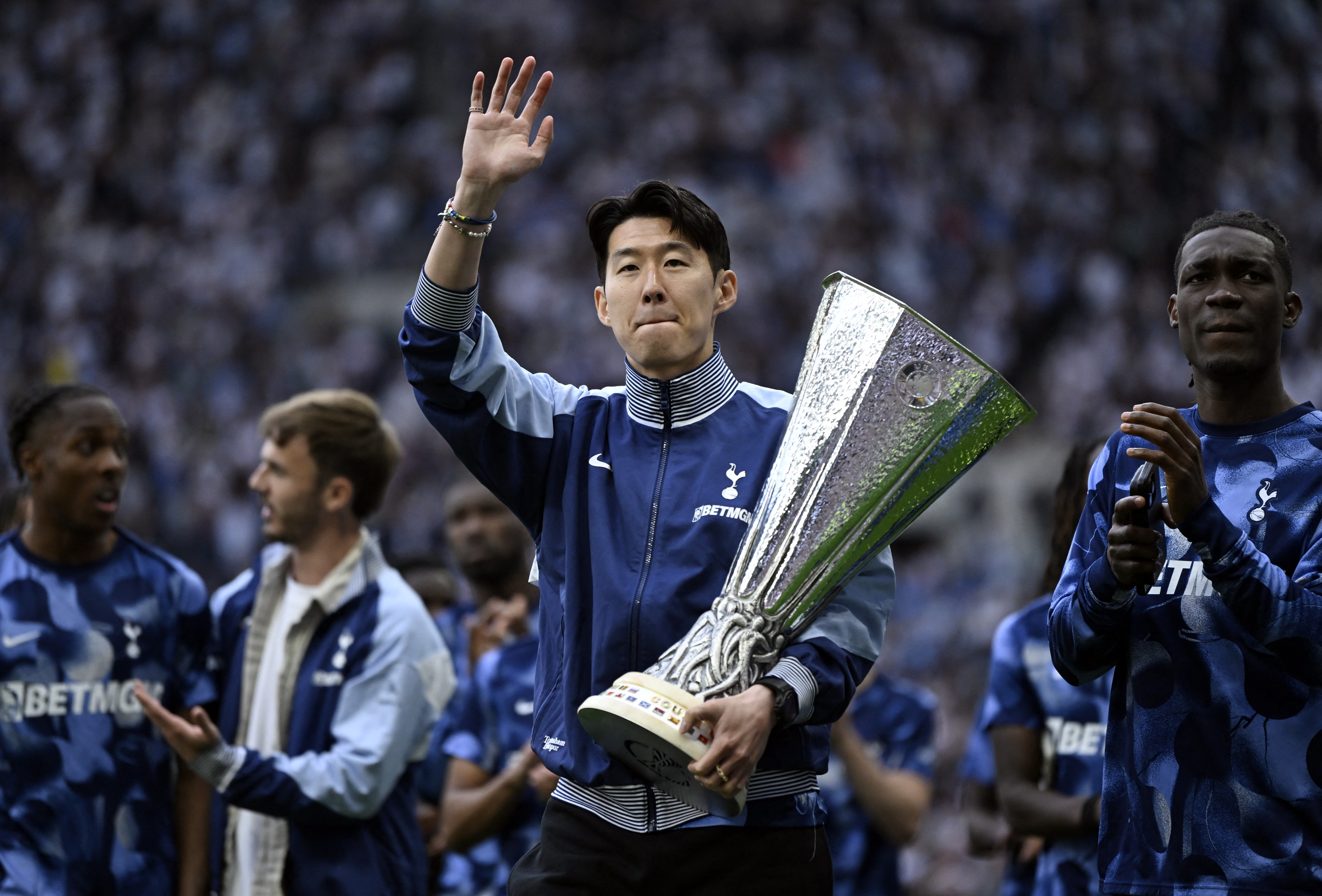 Tottenham Hotspur's Heung-min Son waves to fans whilst holding the Europa League trophy