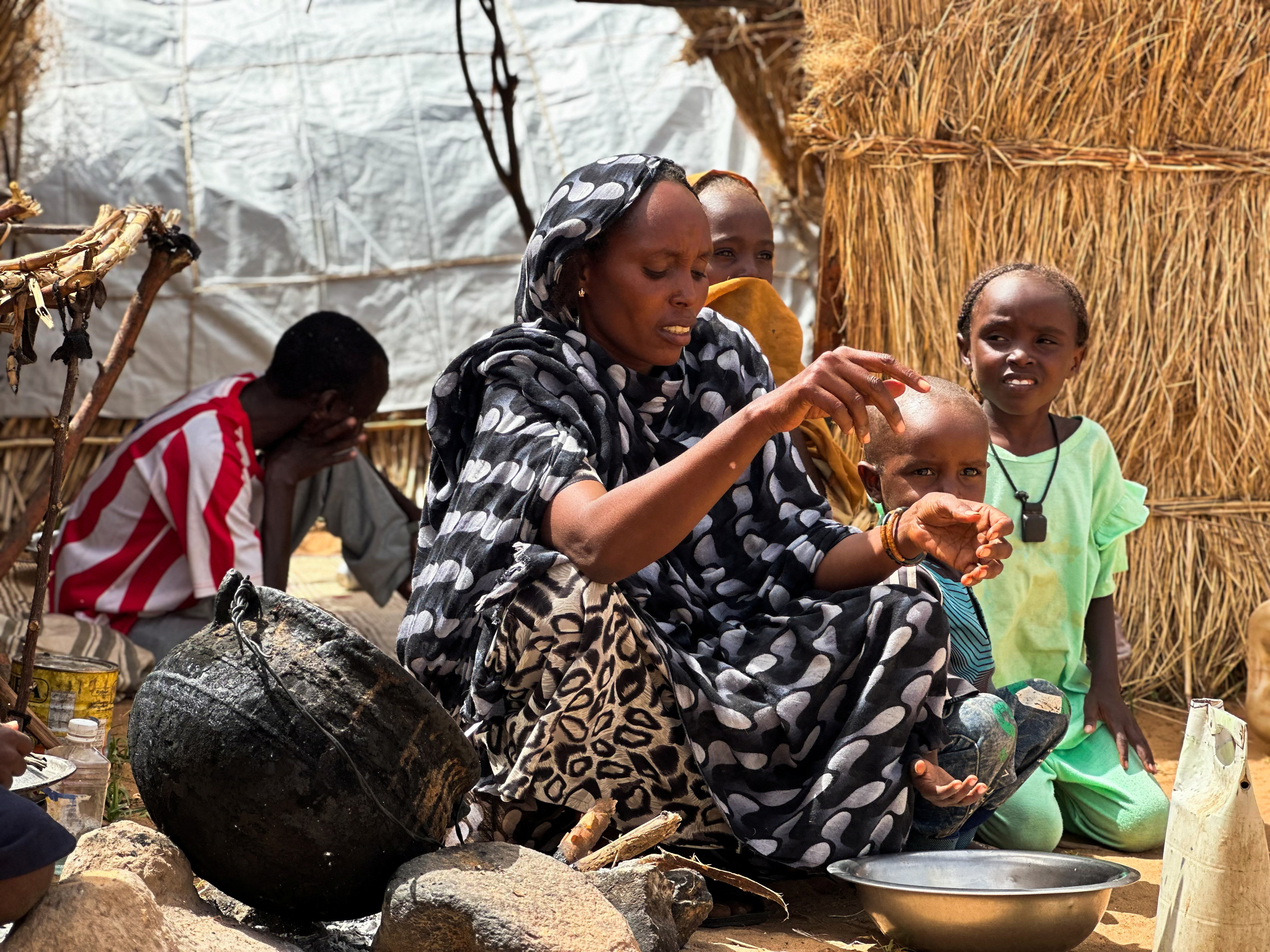 Houda Ali Mohammed, 32, a displaced Sudanese mother of four, prepares food at a camp shelter amid the ongoing conflict between the paramilitary Rapid Support Forces (RSF) and the Sudanese army, in Tawila, North Darfur, Sudan, July 30, 2025. REUTERS/Mohamed Jamal