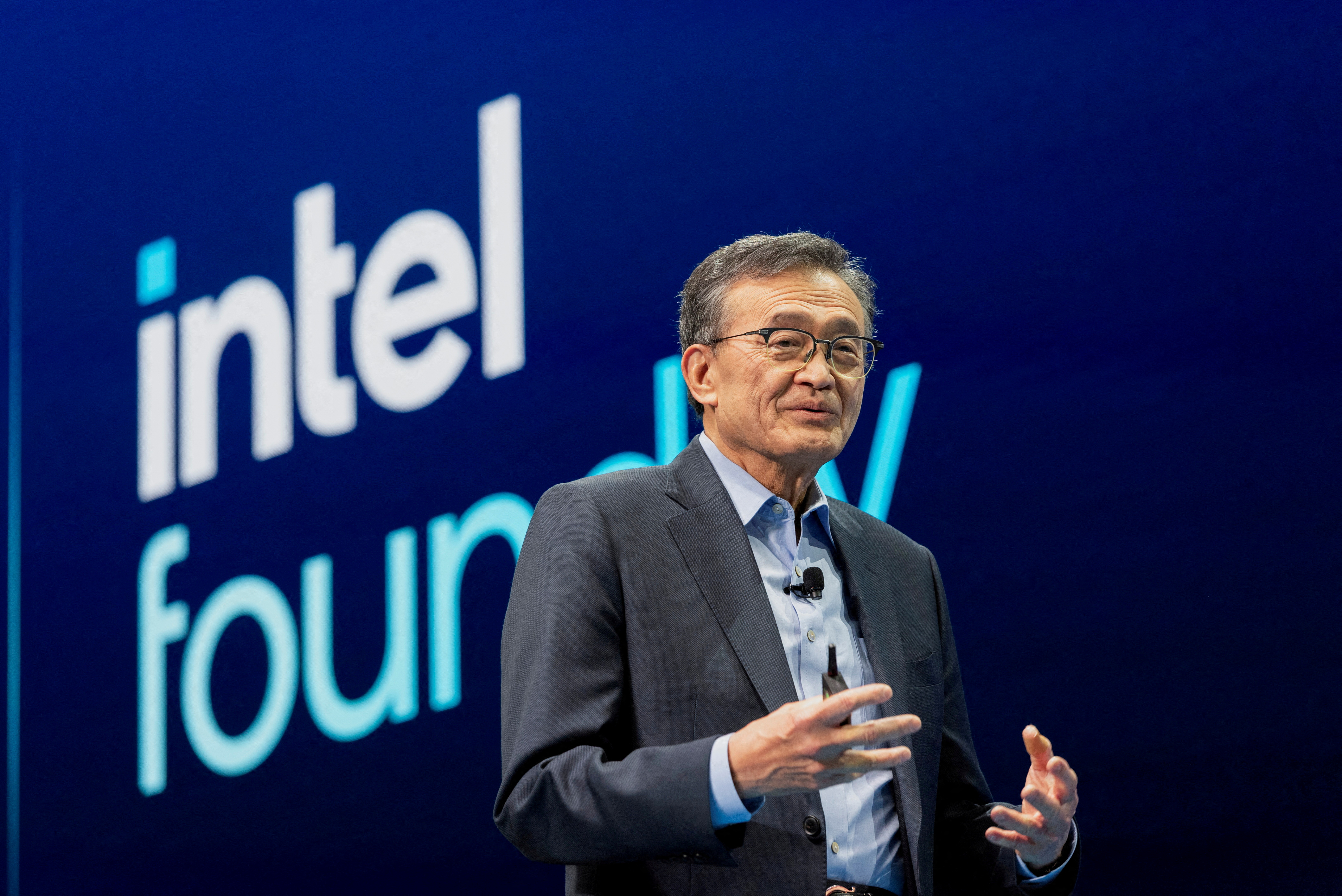 Lip-Bu Tan stands in front of a screen with the logo for Intel