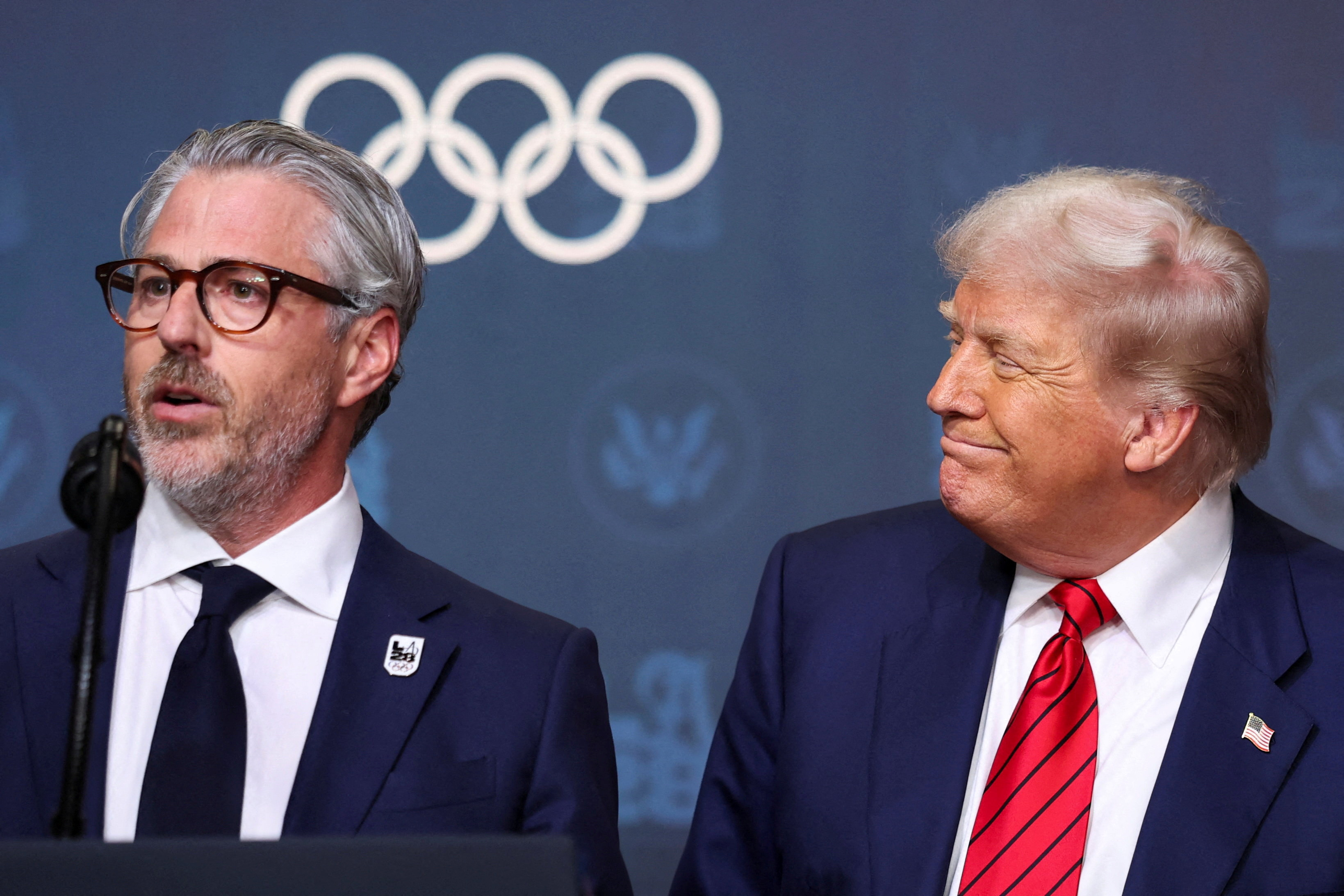 US President Donald Trump reacts, as LA28 Chairman Casey Wasserman speaks, before signing an executive order to create a White House Olympics task force to handle security and other issues related to the LA 2028 summer Olympic games