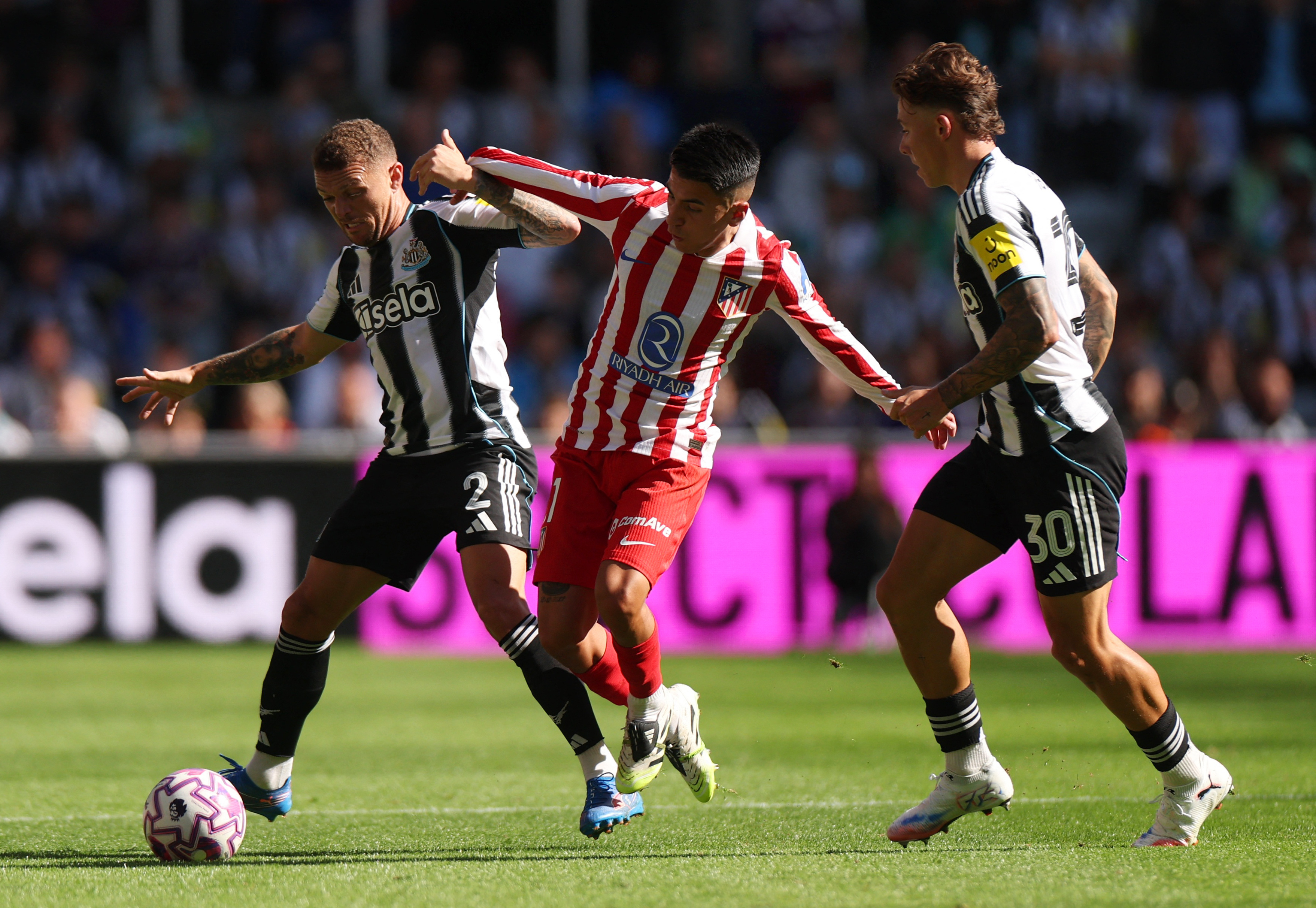 Newcastle United's Kieran Trippier and Harrison Ashby in action with Atletico Madrid's Thiago Almada 