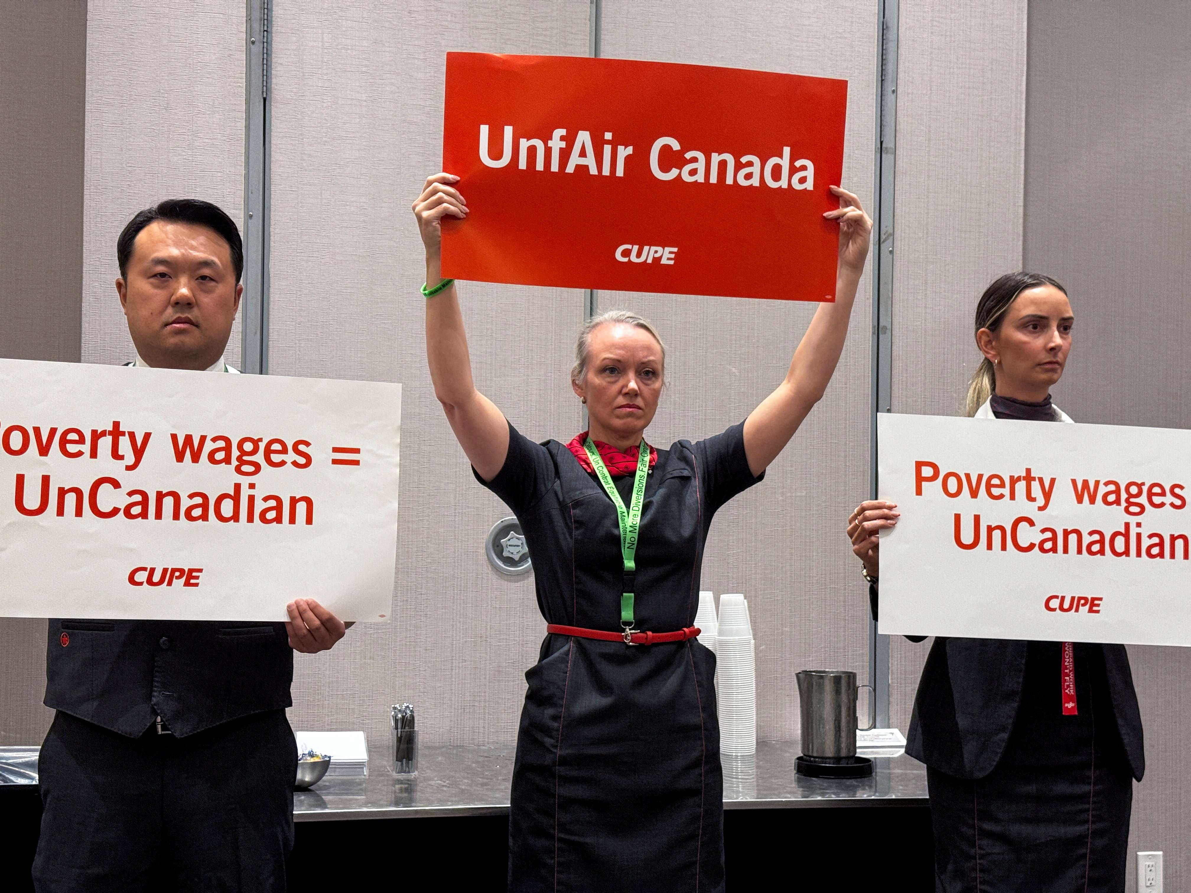 Union activists hold placards that read "UnfAIR Canada" and "Poverty wages = unCanadian"