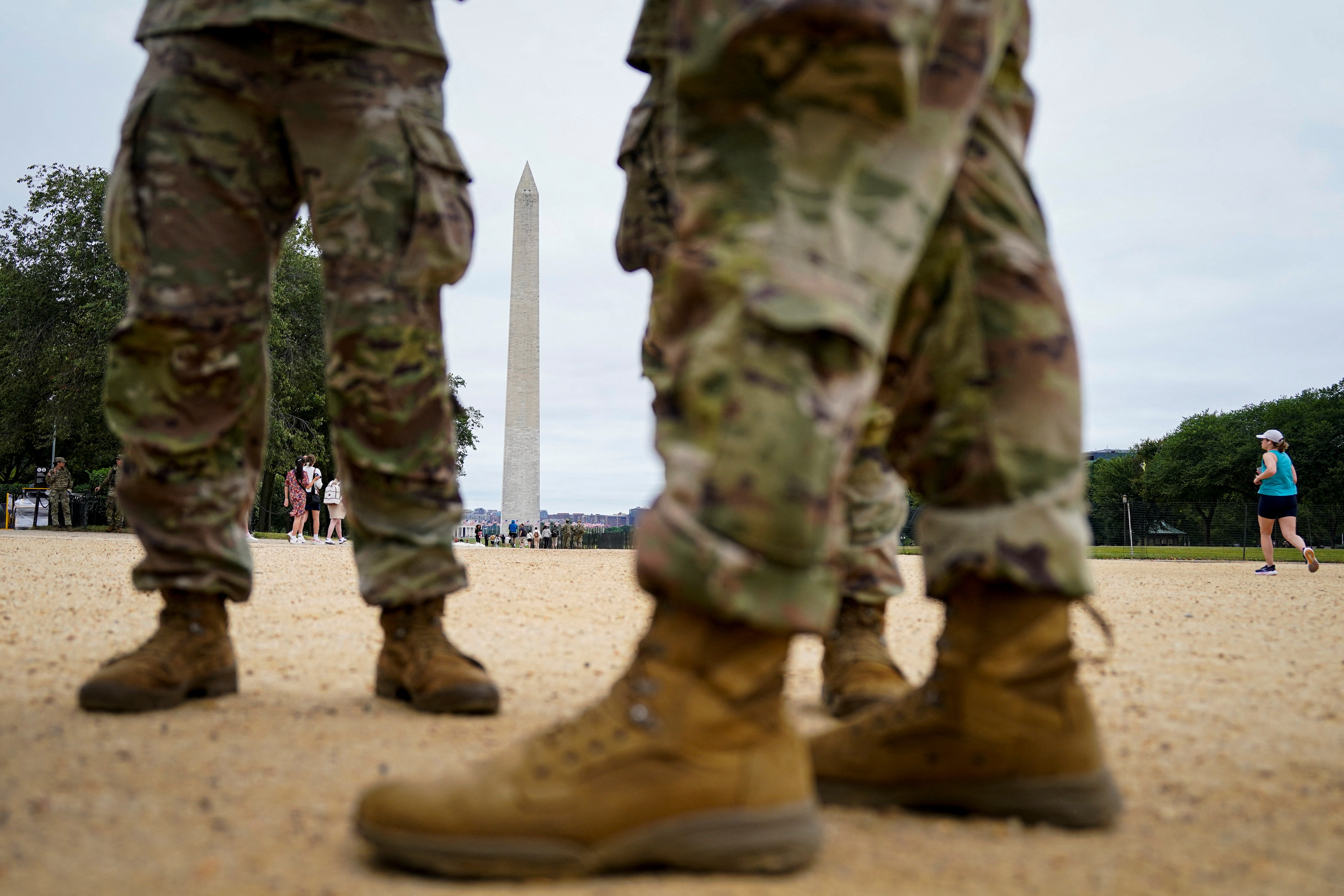 Troops' boots are seen in close-up in front of the Washington Monument