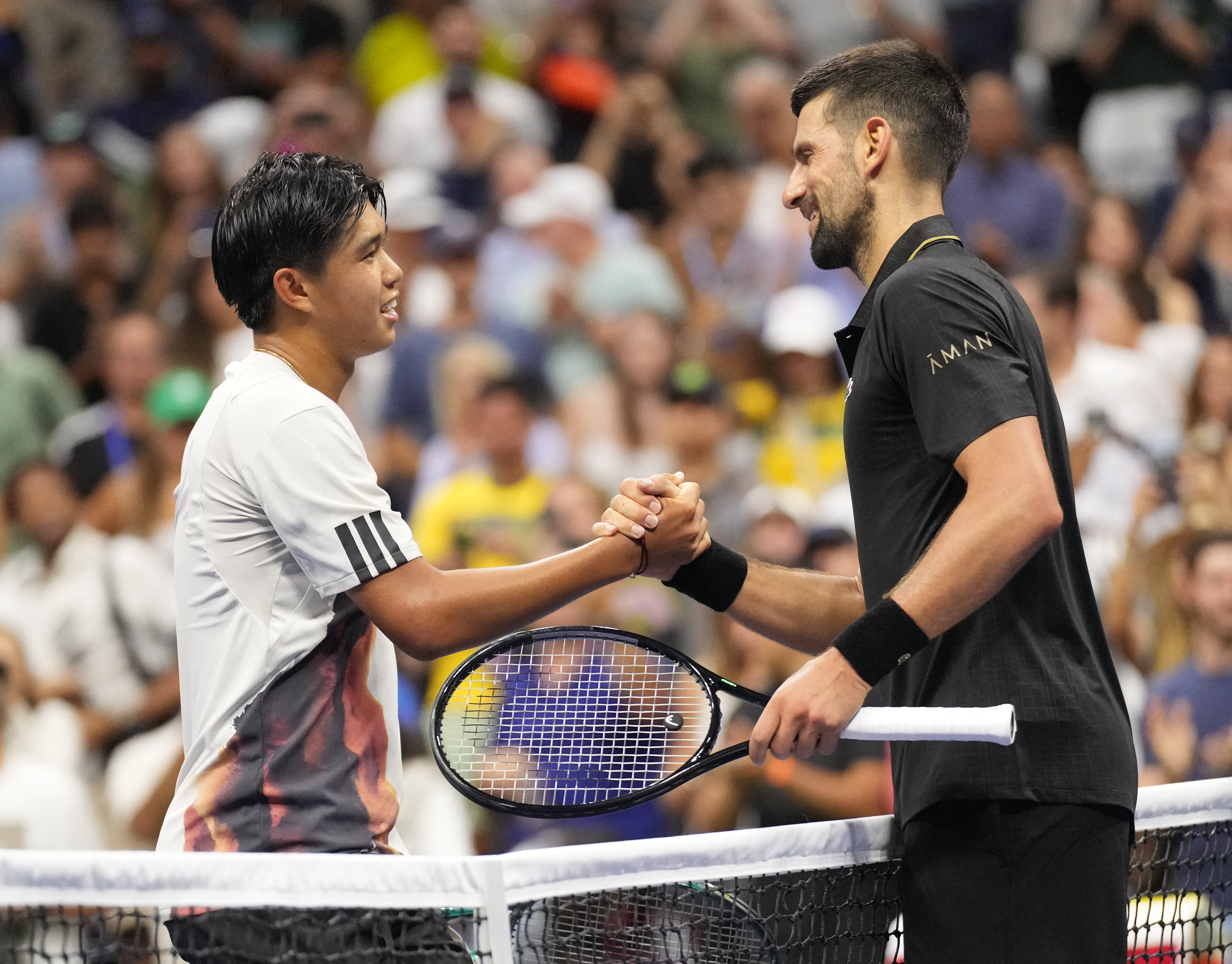Novak Djokovic and Learner Tien shake hands.