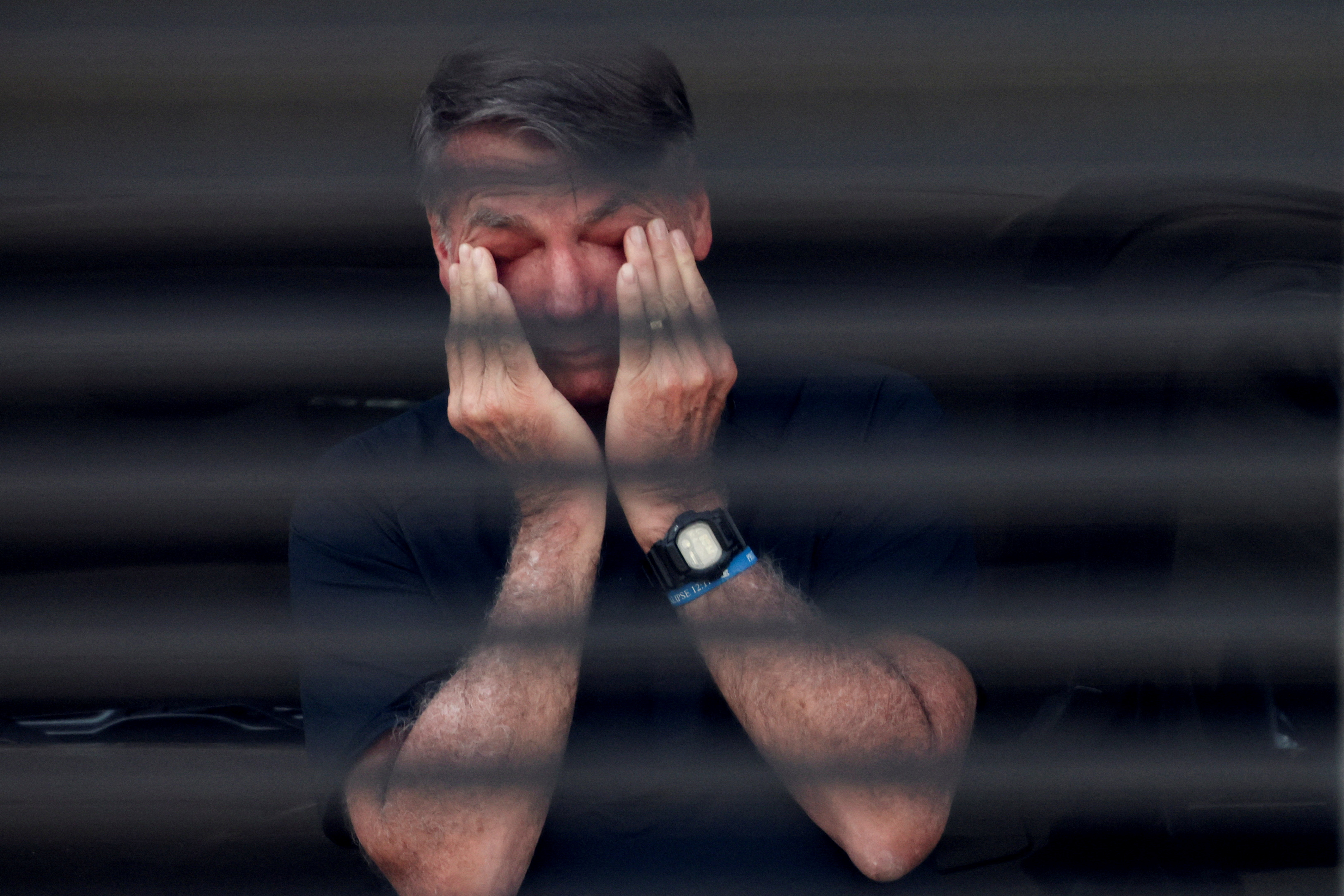 Brazil's former President Jair Bolsonaro covers his eyes at his home while under house arrest earlier this month. [File: Adriano Machado/Reuters]