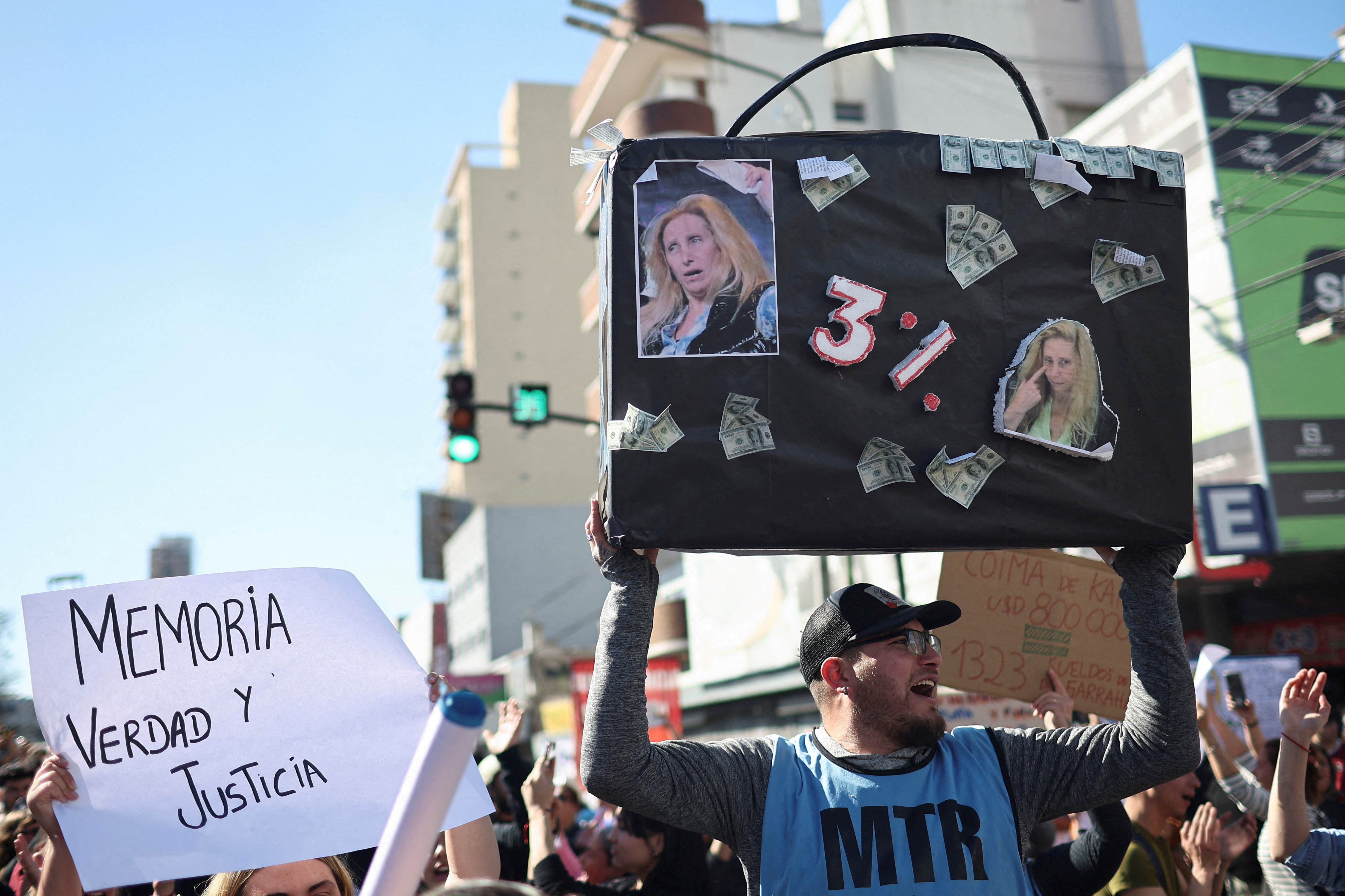 Opponents of Javier Milei hold up a poster with images of his sister Karina and the text "3%", a reference to a bribery scandal