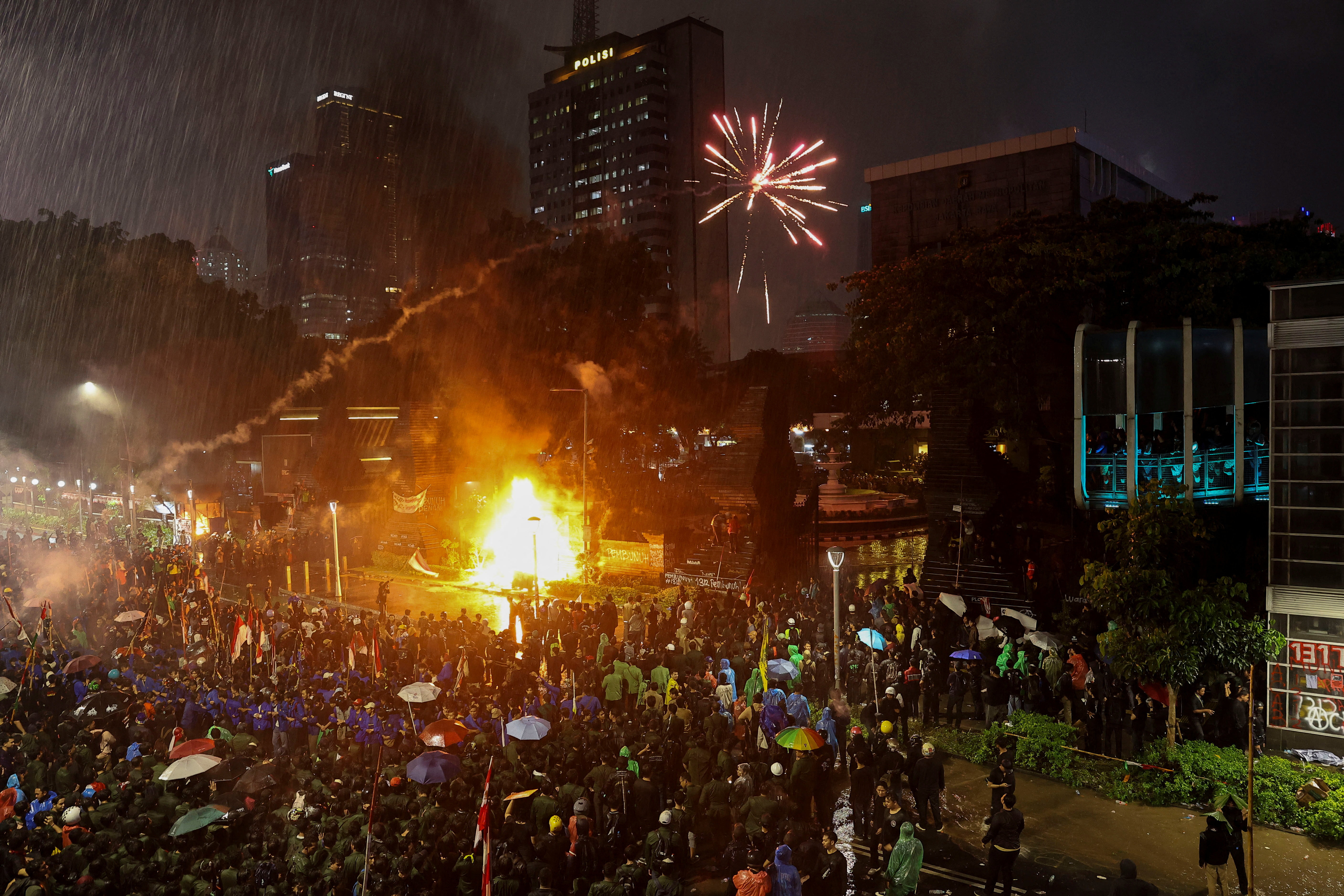 Fireworks are fired by protesters over Jakarta police headquarters during a protest.