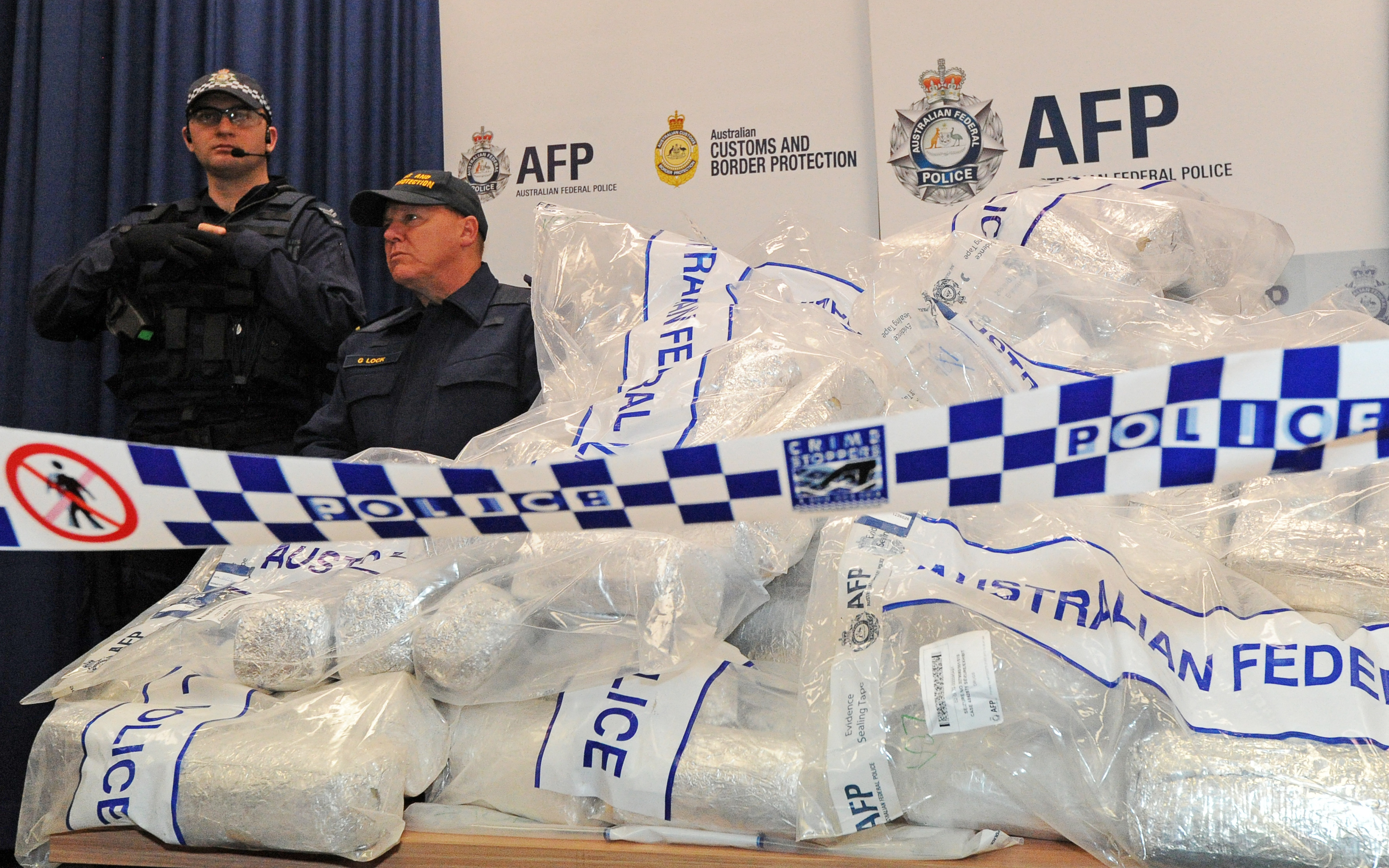 Australian Federal Police (AFP) guard 525 million USD worth of crystal methamphetamine ('ice') and heroin after smashing a Hong Kong-based international drugs syndicate in Sydney on July 31, 2012. It was the largest haul of ice (306 kilograms) in Australian history and the third-biggest heroin bust (252 kilograms) and was the culmination of an 11-month operation following a tip-off from the US Drug Enforcement Administration. AFP PHOTO / Torsten BLACKWOOD (Photo by TORSTEN BLACKWOOD / AFP)