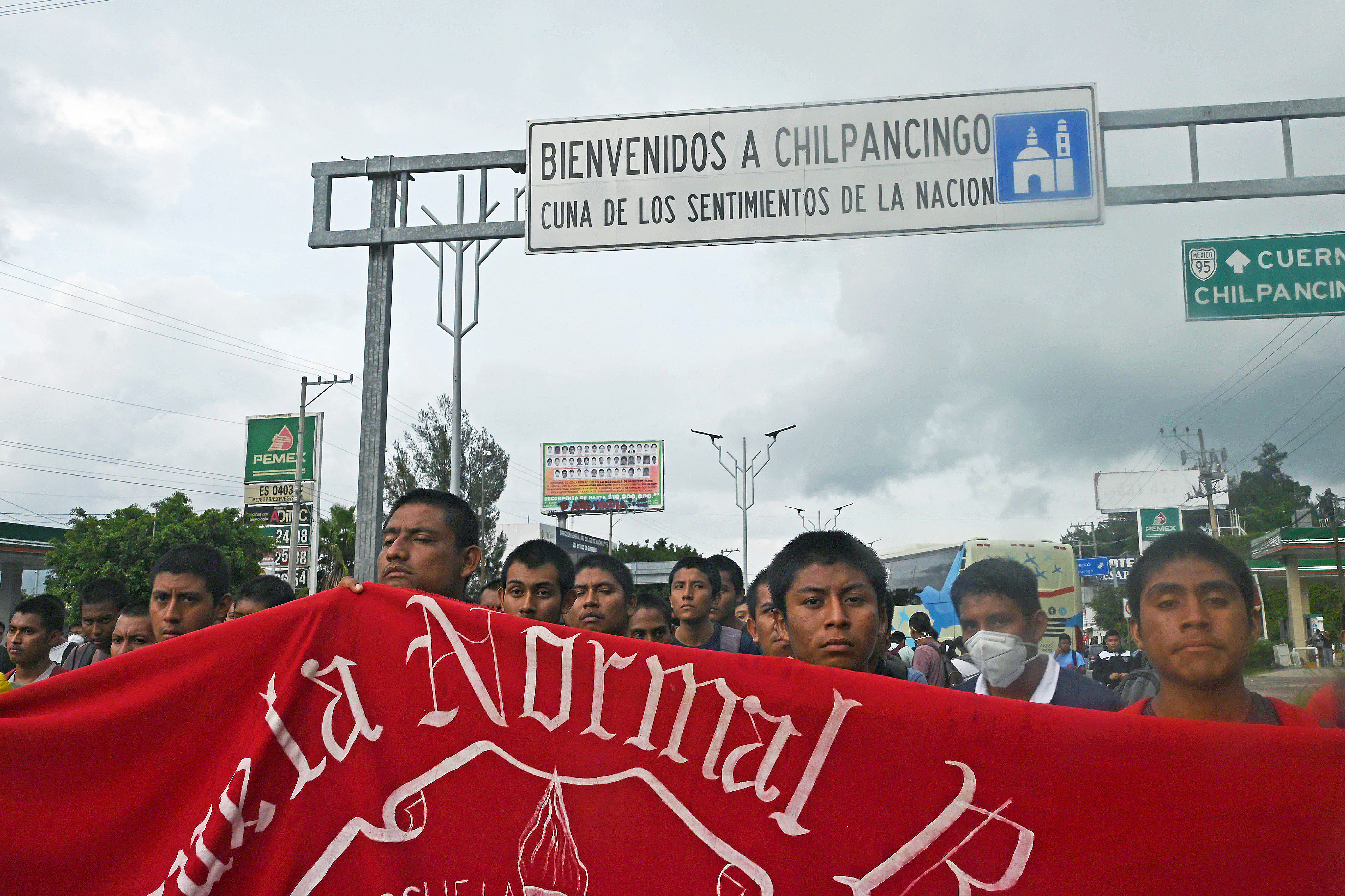 Protesters hold up a banner with the name of a "normal" school at a demonstration in Mexico