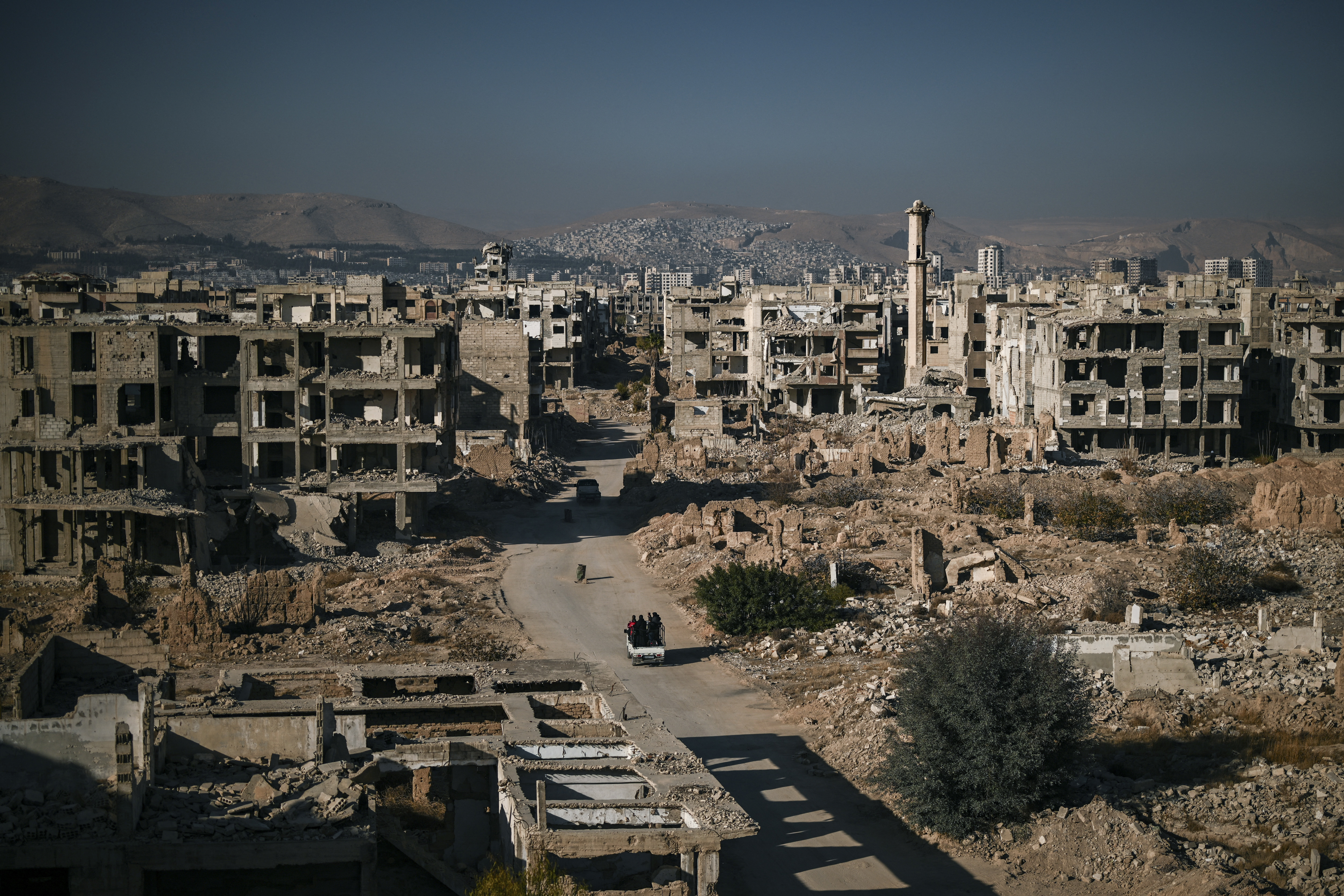 Cars drive on a road amid building destruction in the Syrian town of Jobar in Eastern Ghouta on the outskirts of Damascus