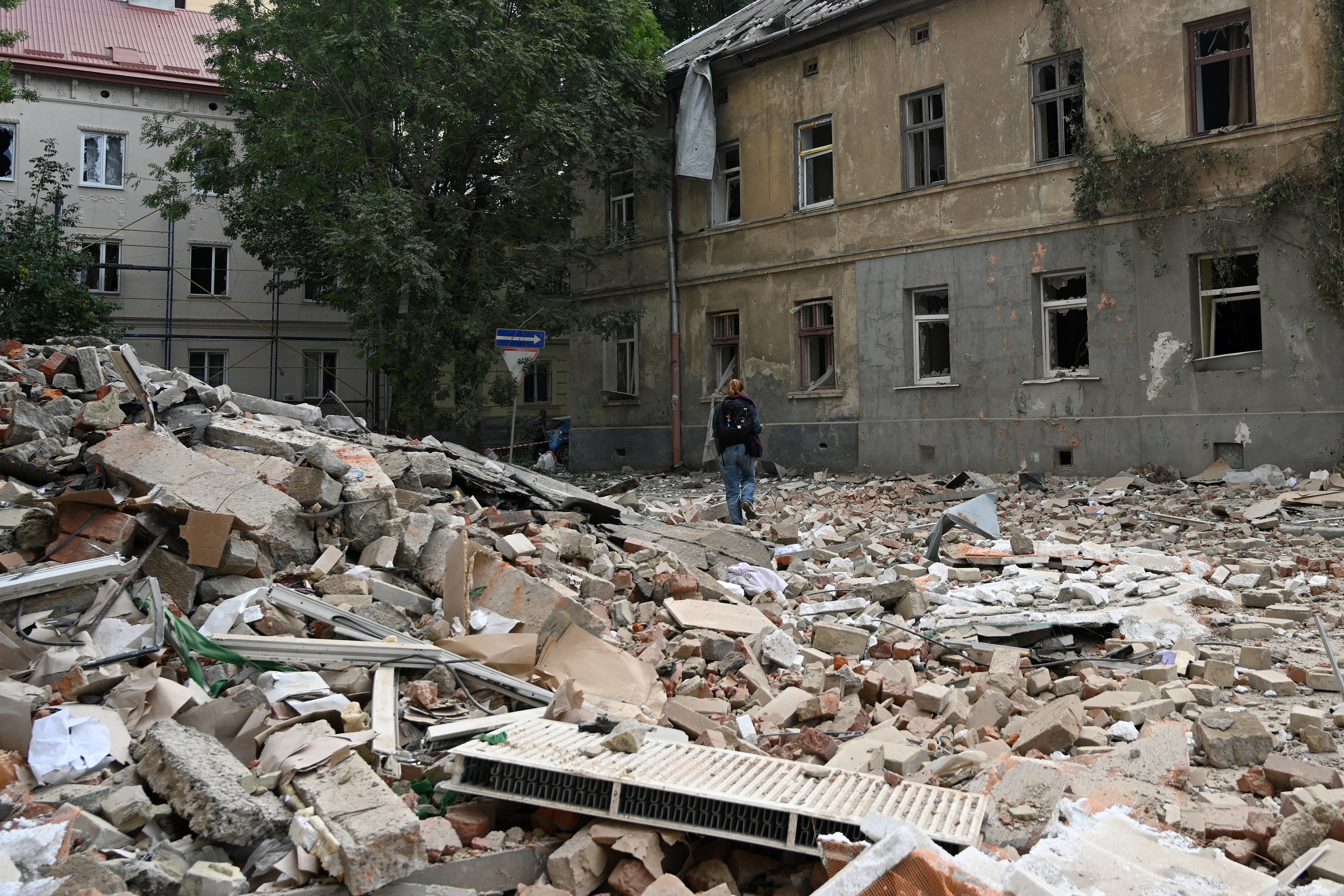 A person walks past a residential building damaged following Russian air attacks in the western Ukrainian city of Lviv on August 21, 2025, amid the Russian invasion of Ukraine. Russia launched hundreds of drones and missiles at Ukraine overnight, the Ukrainian air force said on August 21, 2025, Moscow's largest attack in weeks after US-led efforts to halt the Kremlin's invasion.