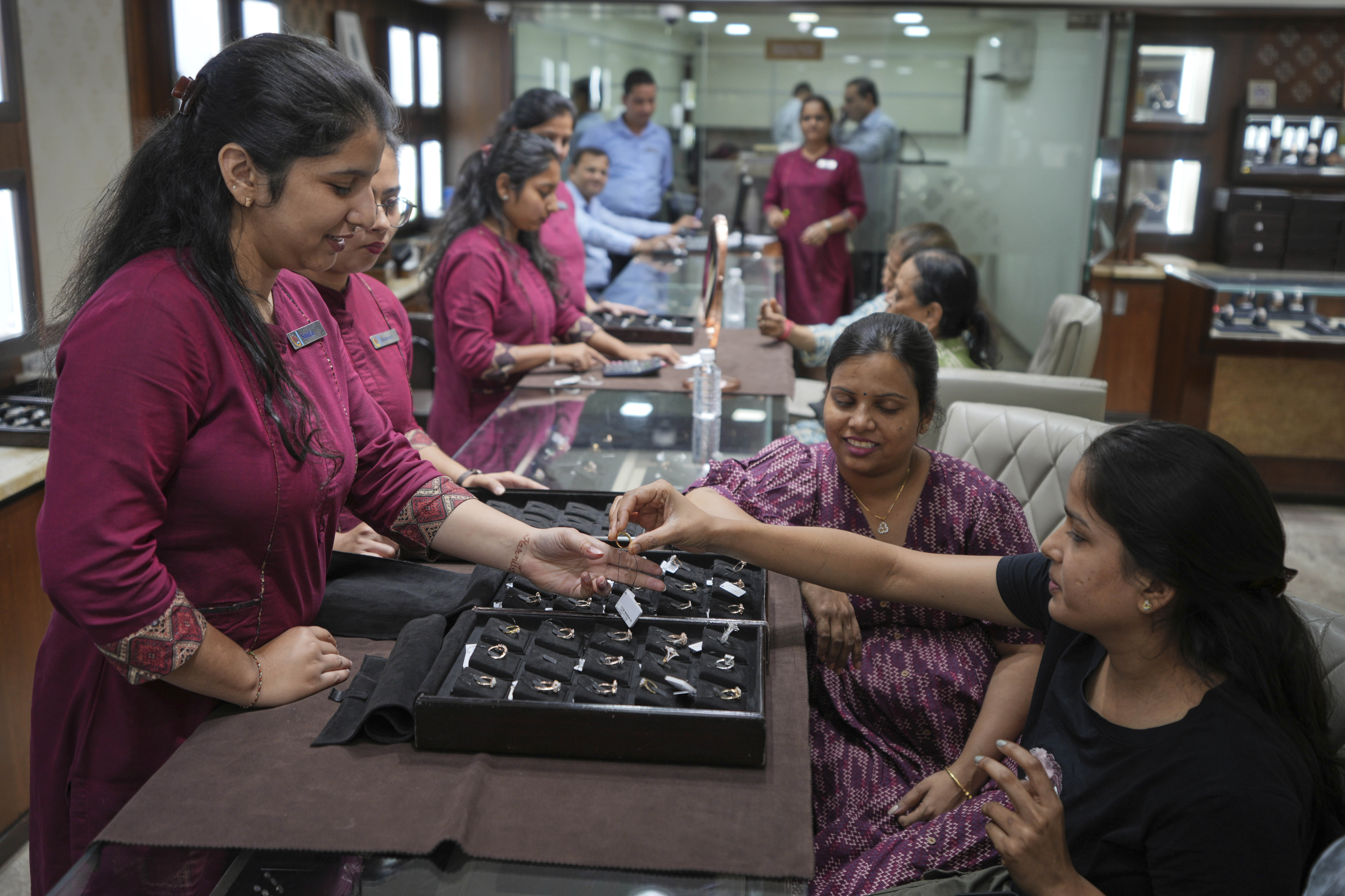 A salesperson shows a diamond ring to a prospective buyer at a jewelry shop in Ahmedabad, India, on April 14, 2025. (AP Photo/Ajit Solanki)