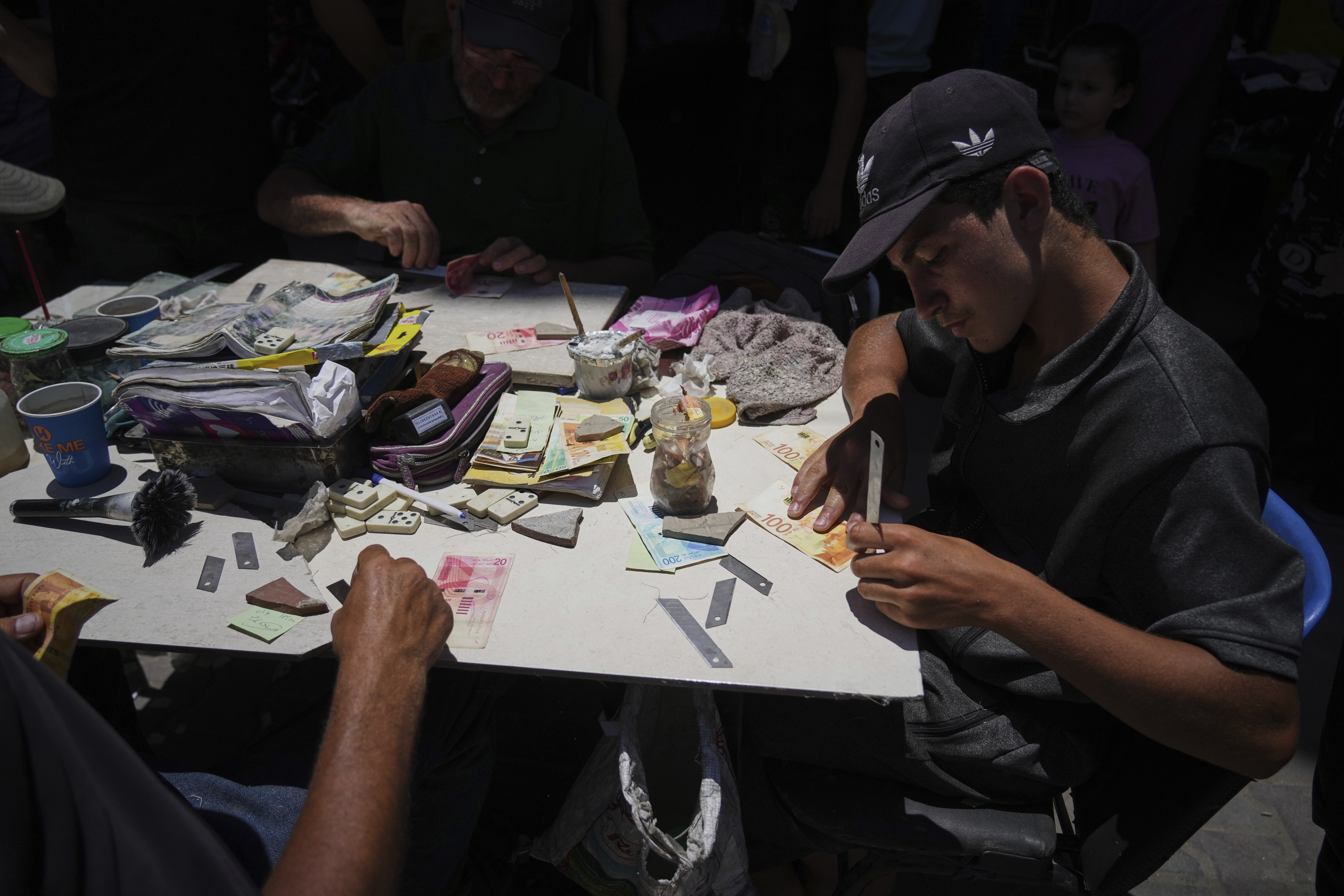 Palestinians repair worn-out Israeli currency Wednesday, July 9, 2025, in Gaza City. (AP Photo/Jehad Alshrafi)