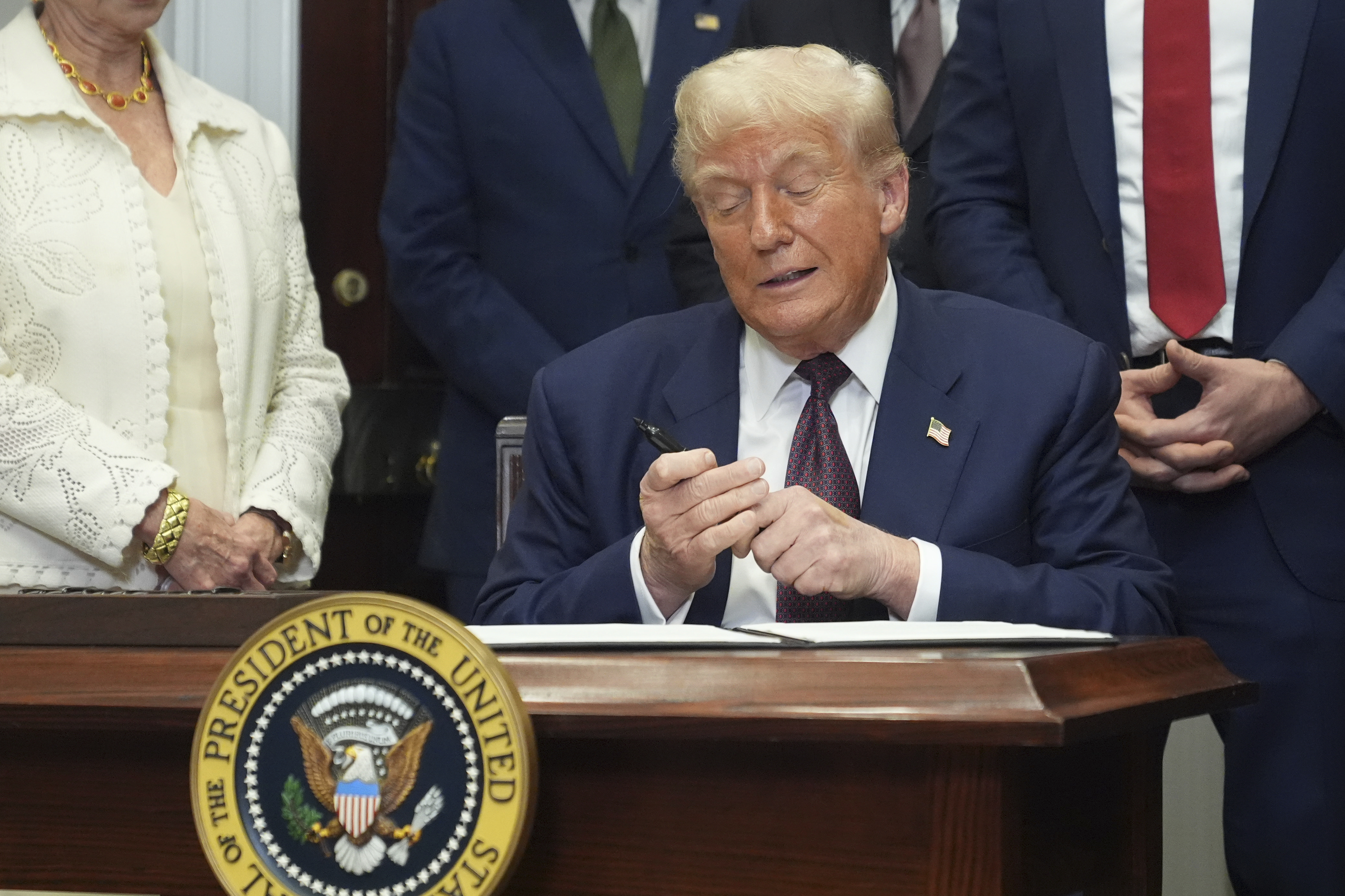 President Donald Trump signs an executive order restarting the Presidential Fitness Test in public schools, Thursday, July 31, 2025, in the Roosevelt Room of the White House in Washington. (AP Photo/Jacquelyn Martin)