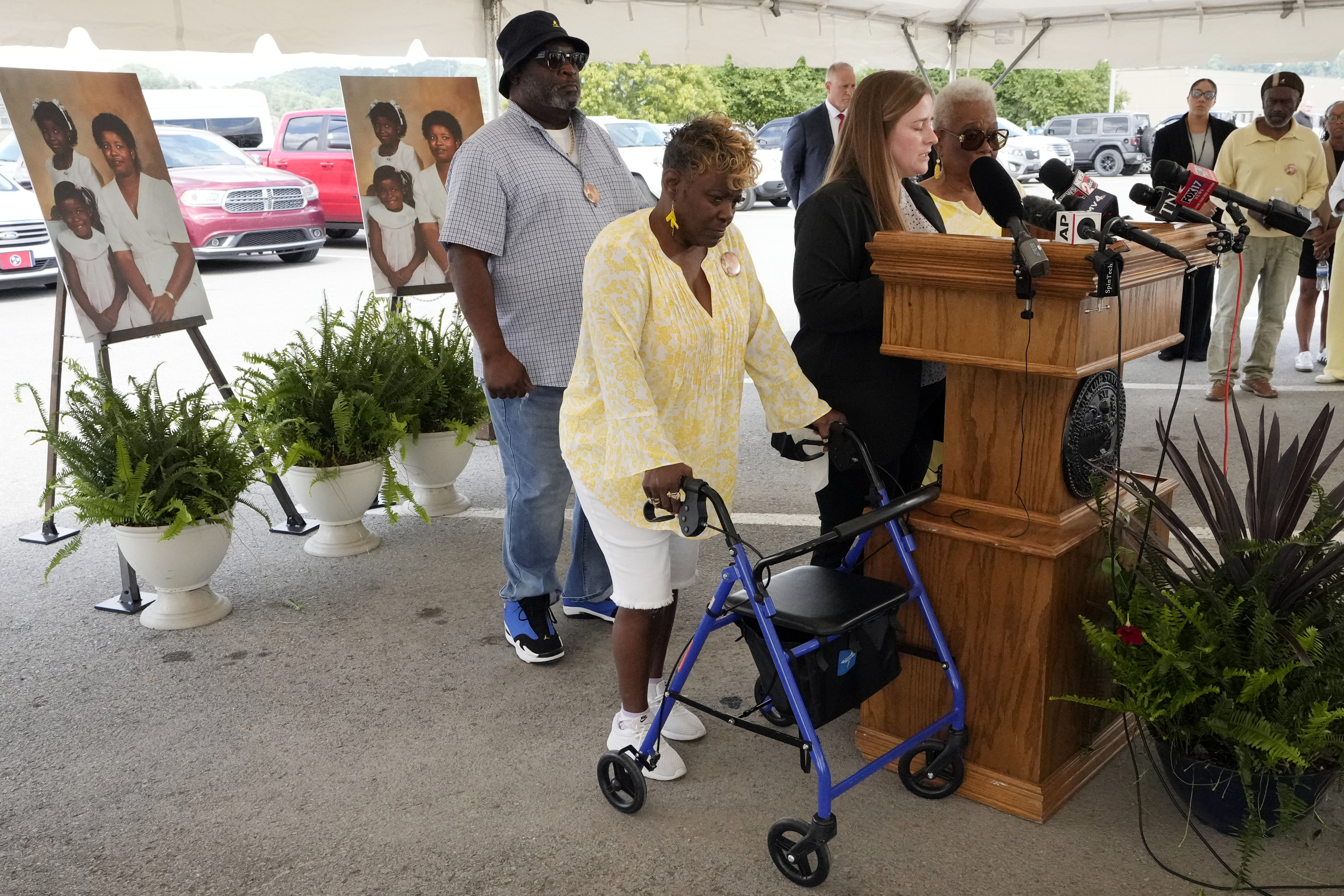 Relatives of the Clay family, the victims in a 1988 triple murder, gather for an outdoor press conference under a tent.