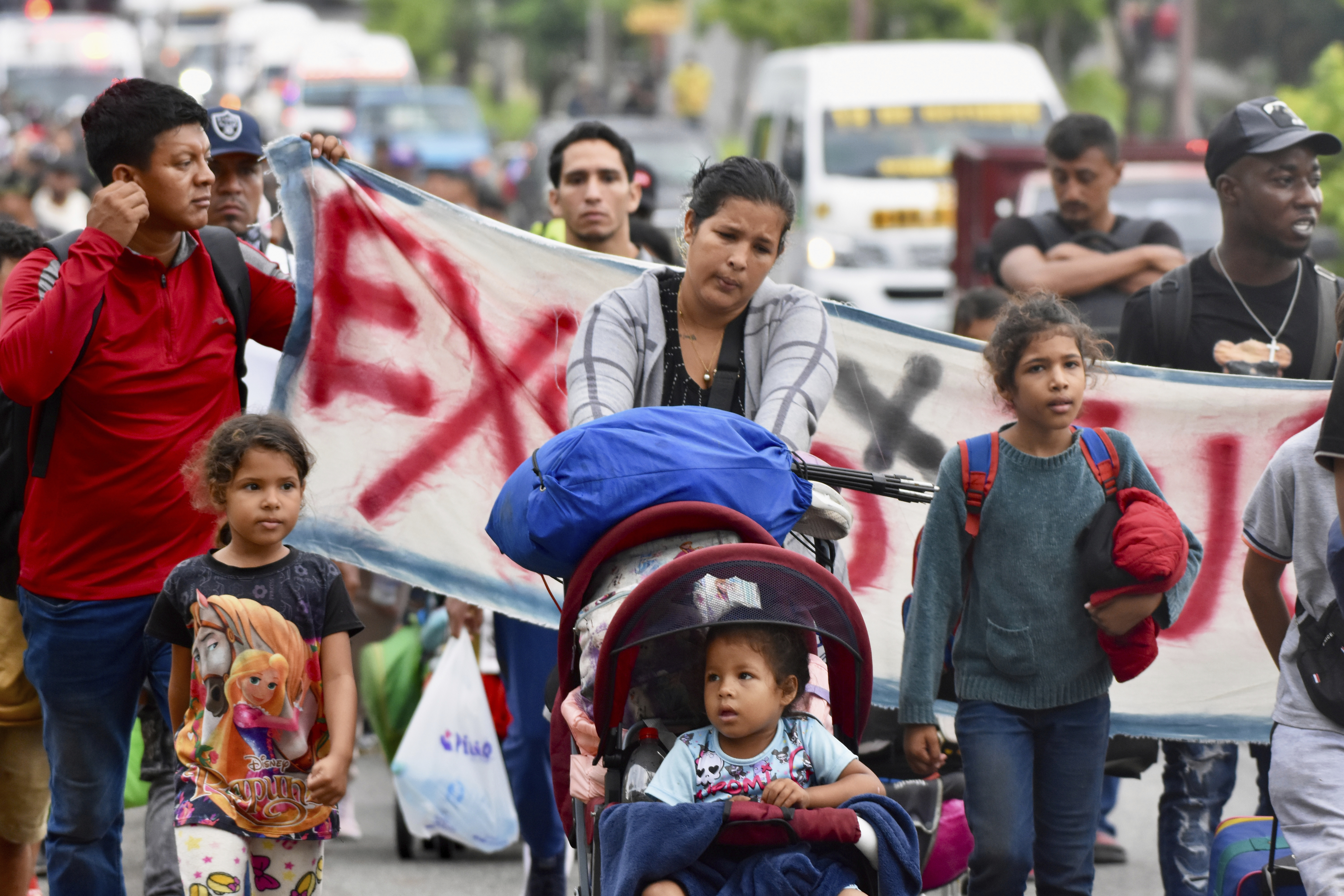 Mothers push strollers as part of a migrant march north through Mexico.
