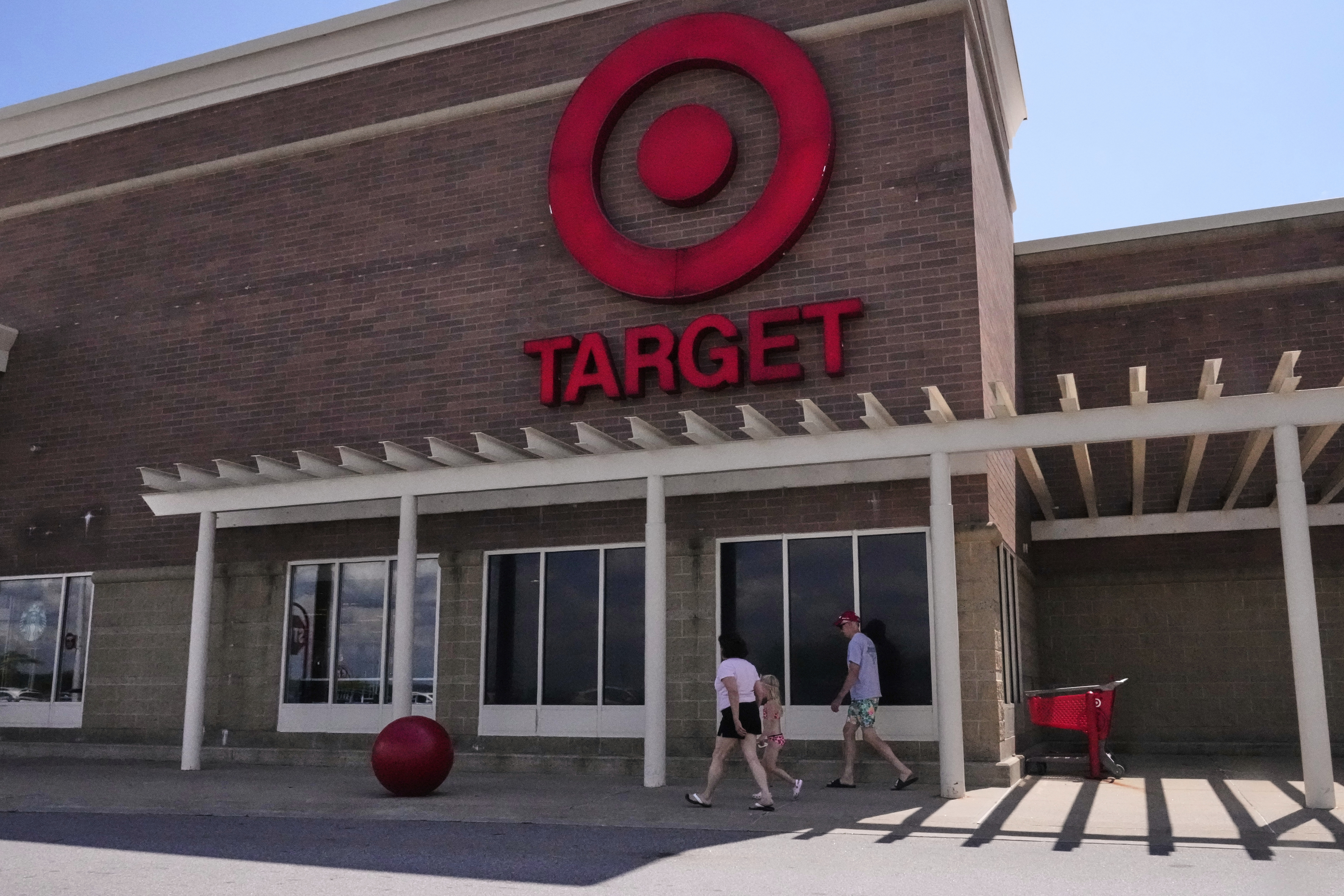 Shoppers walk to the Target store, Thursday, Aug. 14, 2025, in Bedford, N.H. (AP Photo/Charles Krupa)