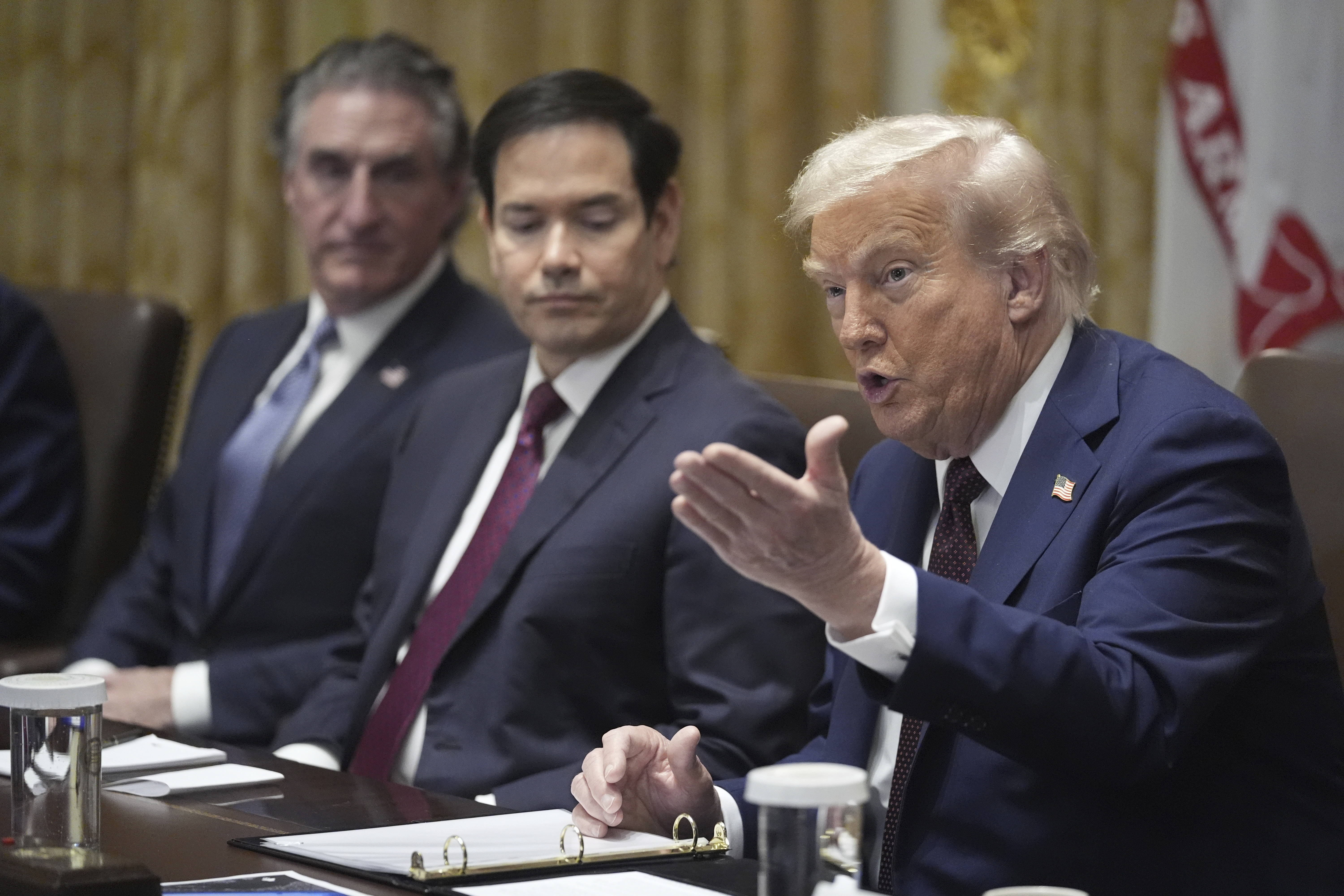 Donald Trump gestures during a cabinet meeting, next to Marco Rubio.