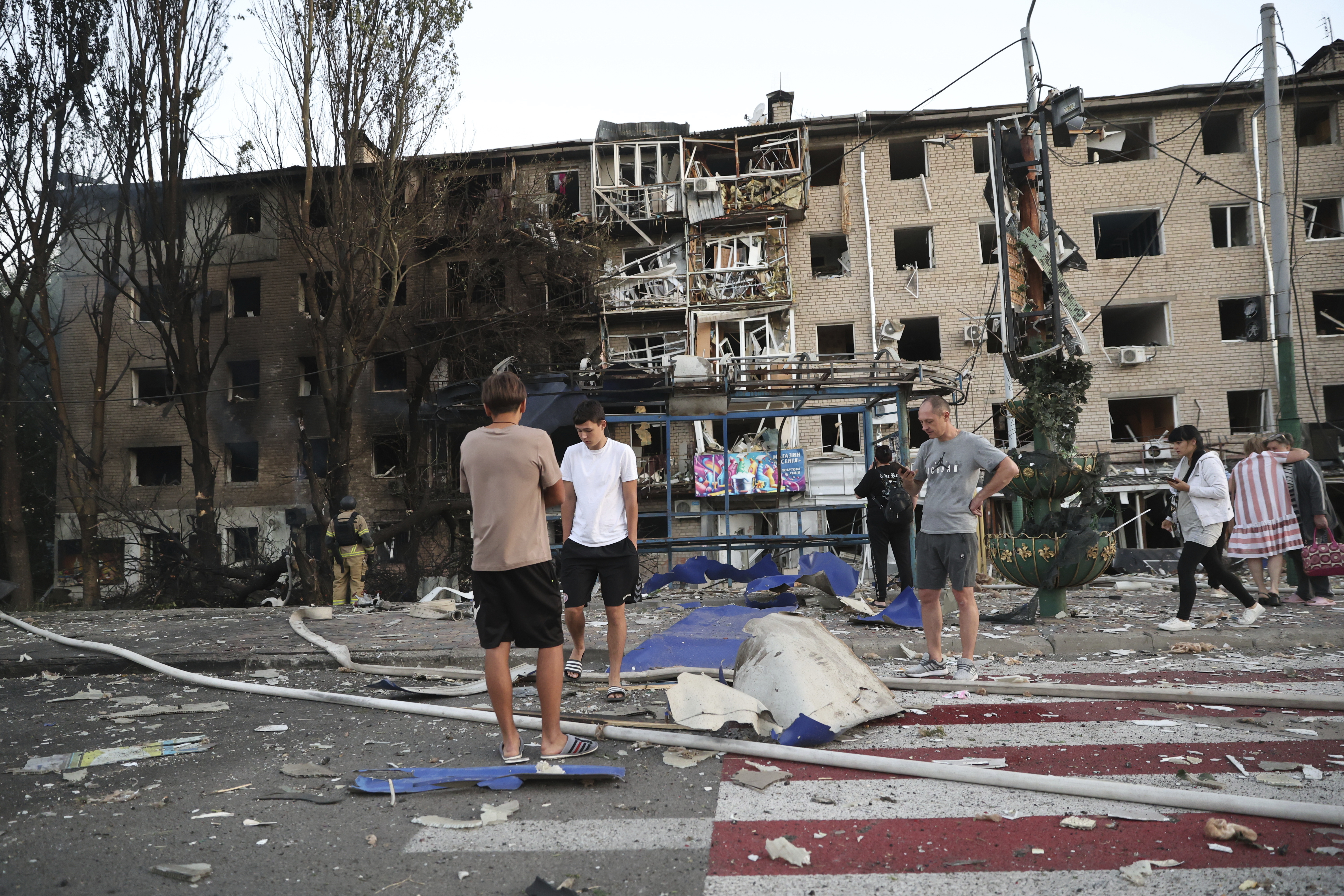 Local residents stand near their destroyed home following Russian air strike in Zaporizhia, Ukraine,