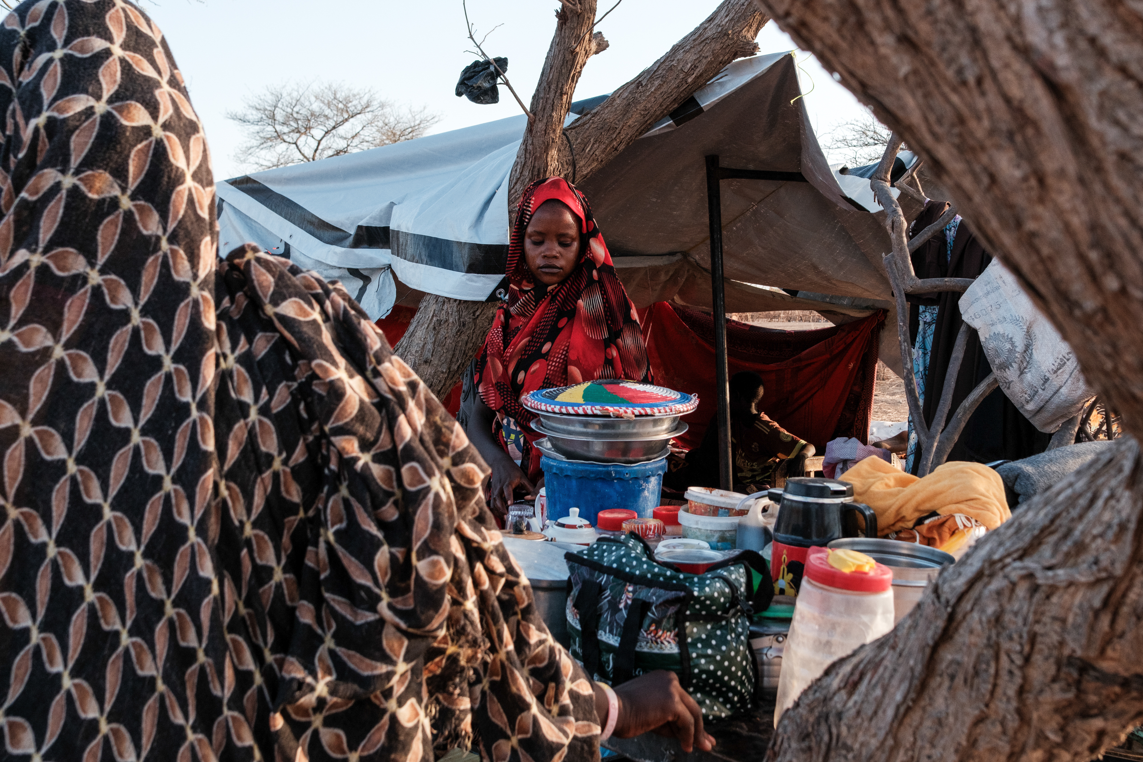 A woman stands with her family's makeshift shelter in al-Hilu IDP camp in Delami County where 12,000 people displaced by the war in Sudan now live in Tongoli on April 22, 2025