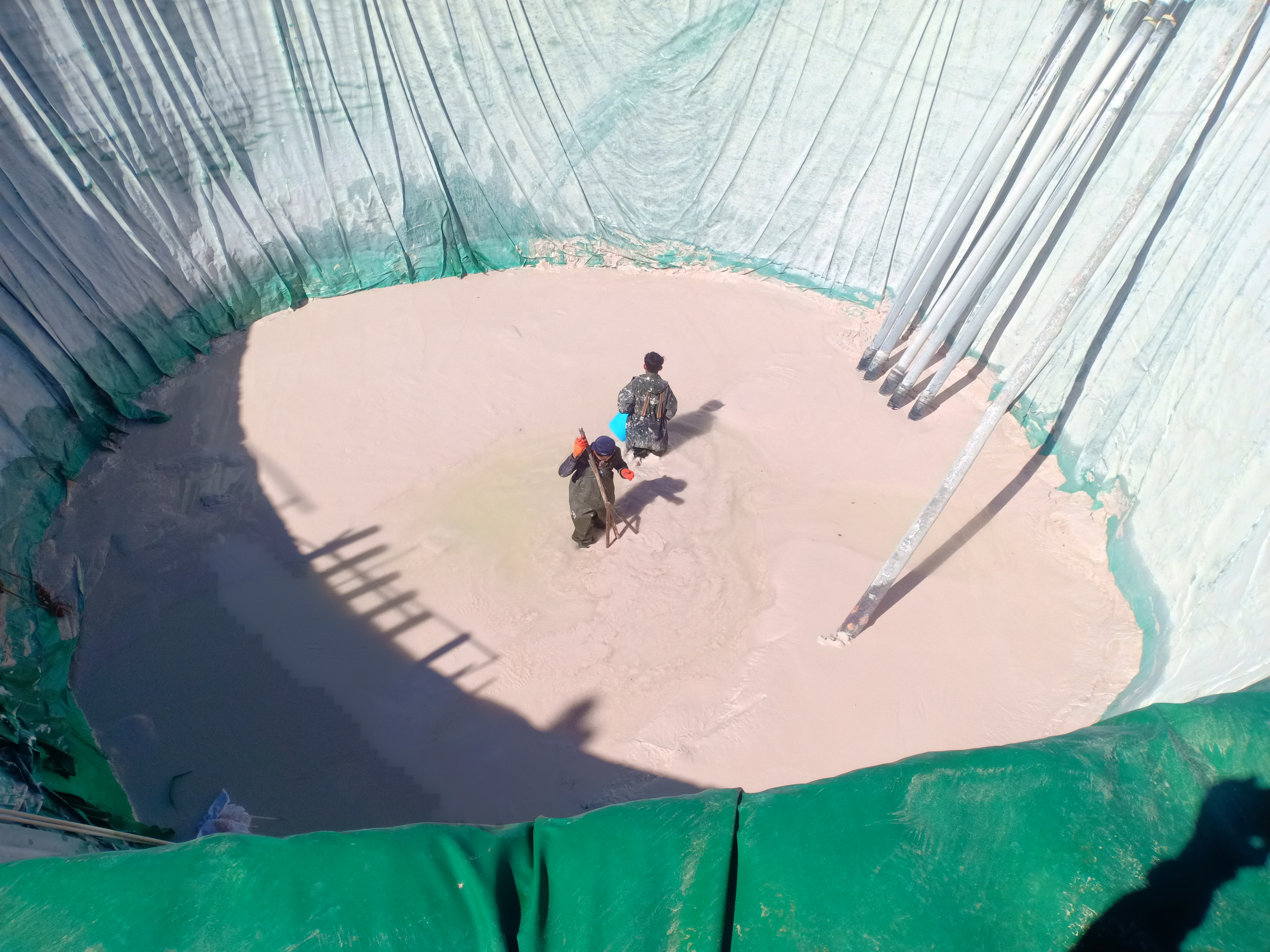 Two men stand inside the collection pool of a rare earths mine in Kachin province, Myanmar, in February 2022. (Global Witness)