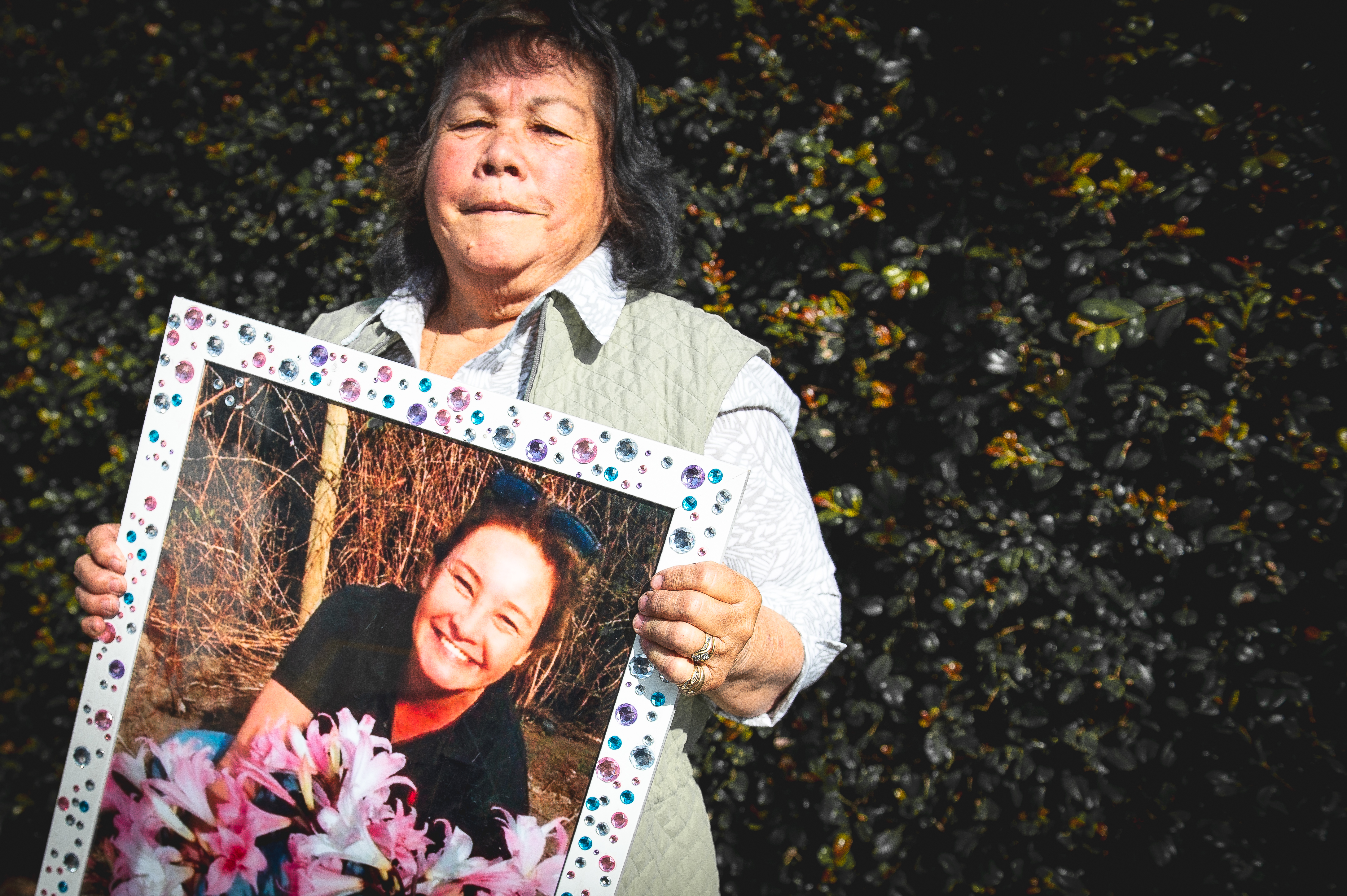 Lee Little with a photograph of her daughter Alicia Little, who was killed by her partner after being driven into by a four-wheel-drive vehicle. Alicia's killer would serve only two years and 8 months jail for the crime [Ali MC/Al Jazeera]