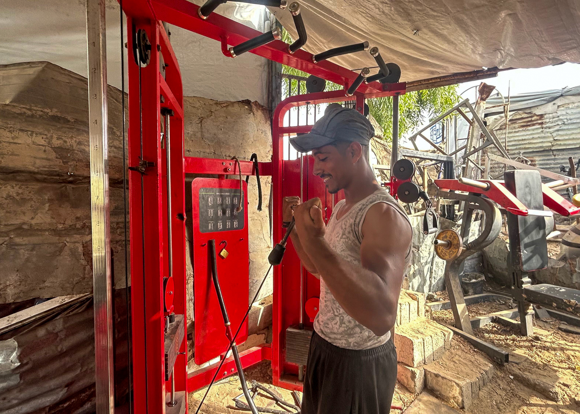Bodybuilder works out in tent gym.