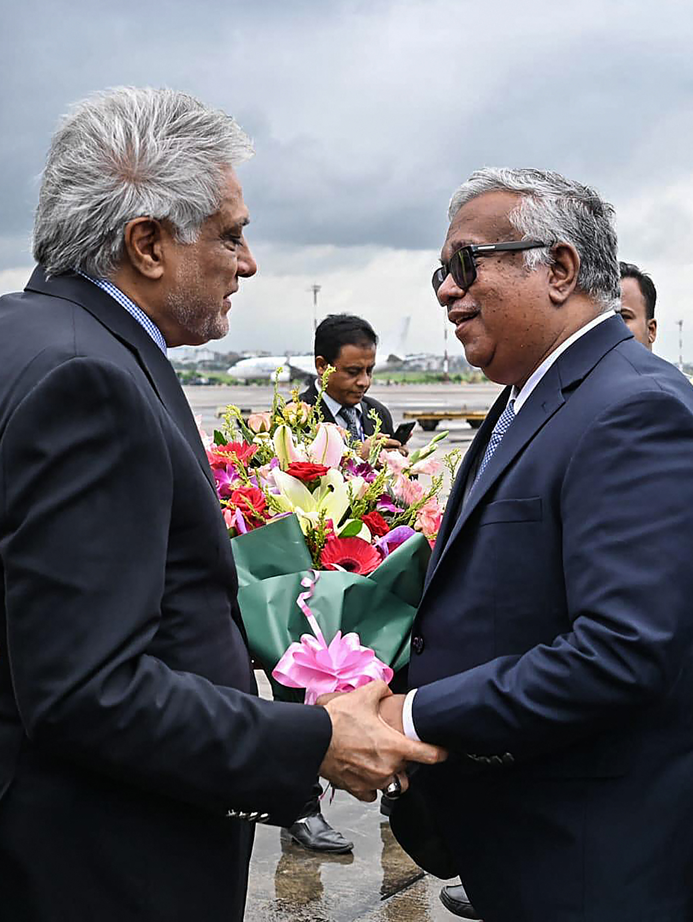 This handout photograph taken and released by Bangladesh's Ministry of Foreign Affairs on August 23, 2025 shows Bangladesh's Foreign Secretary Asad Alam Siam (R) receiving Ishaq Dar (L), Pakistan's Foreign Minister, at the Hazrat Shahjalal International Airport in Dhaka.