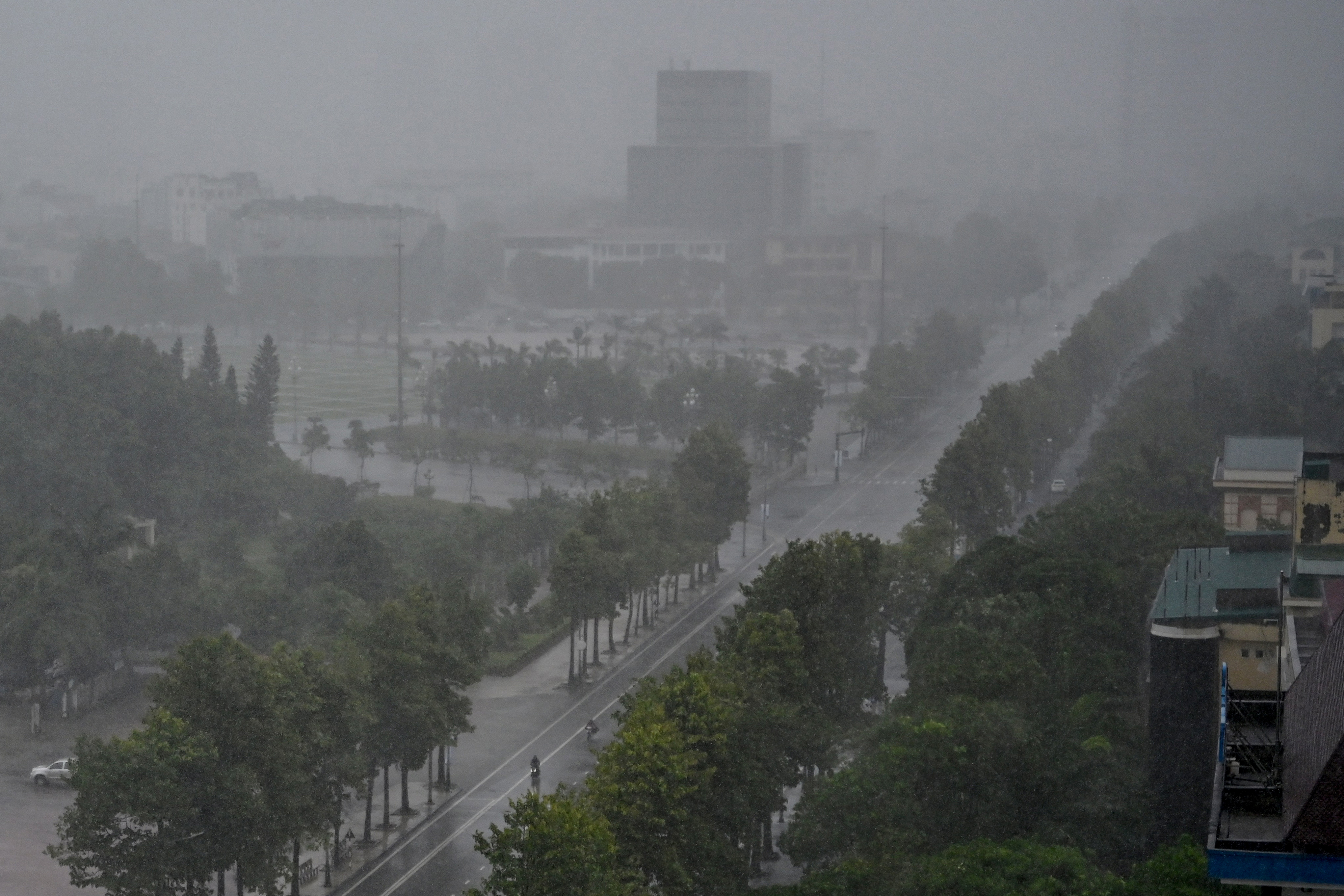 Rain falls above the buildings and a street in Vinh city, Nghe An province on August 25, 2025, before Typhoon Kajiki makes landfall in Vietnam.
