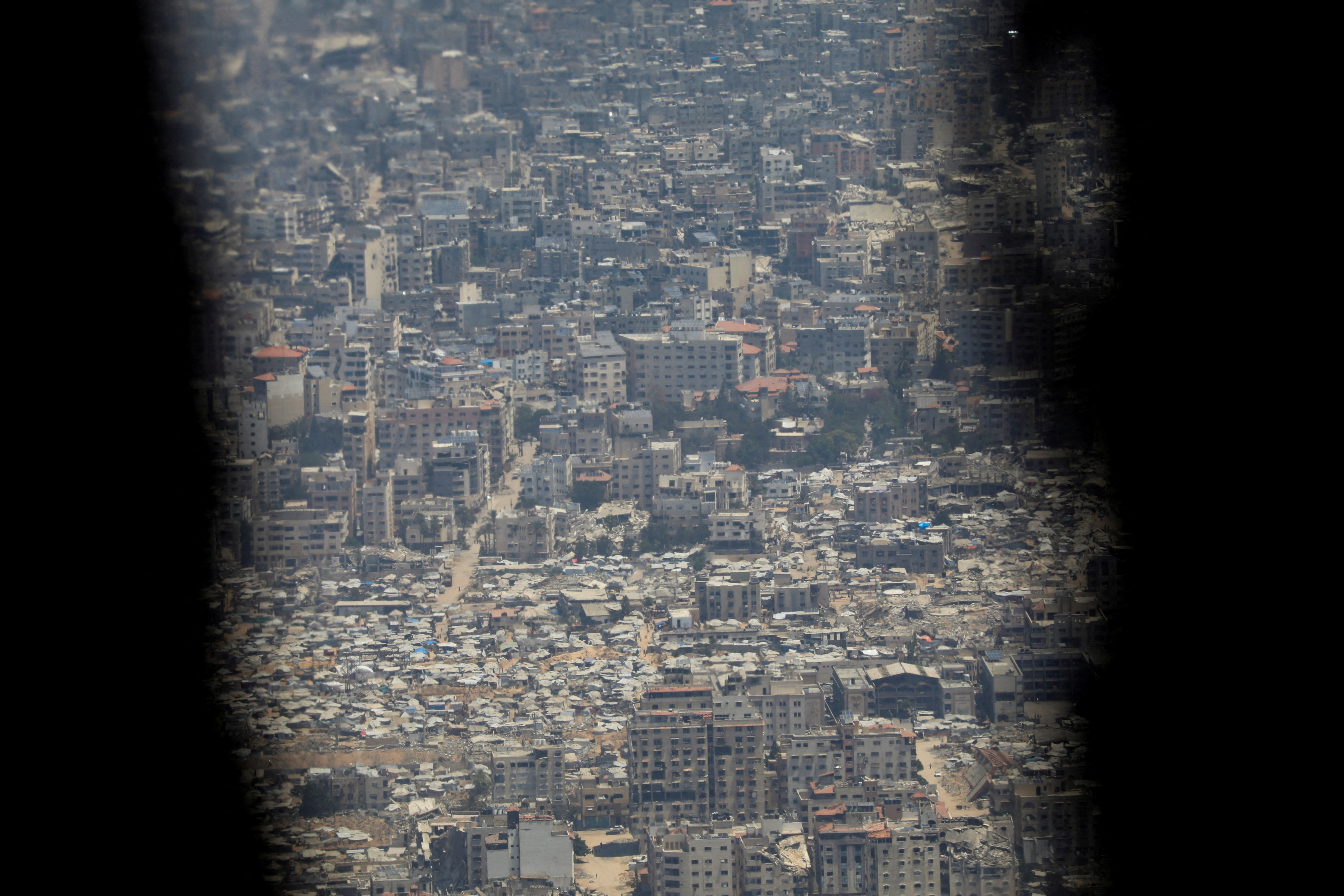 The Gaza Strip is seen from a French military aircraft before humanitarian aid is airdropped over it, in Gaza, August 3, 2025. REUTERS/Alaa Al Sukhni REFILE - QUALITY REPEAT