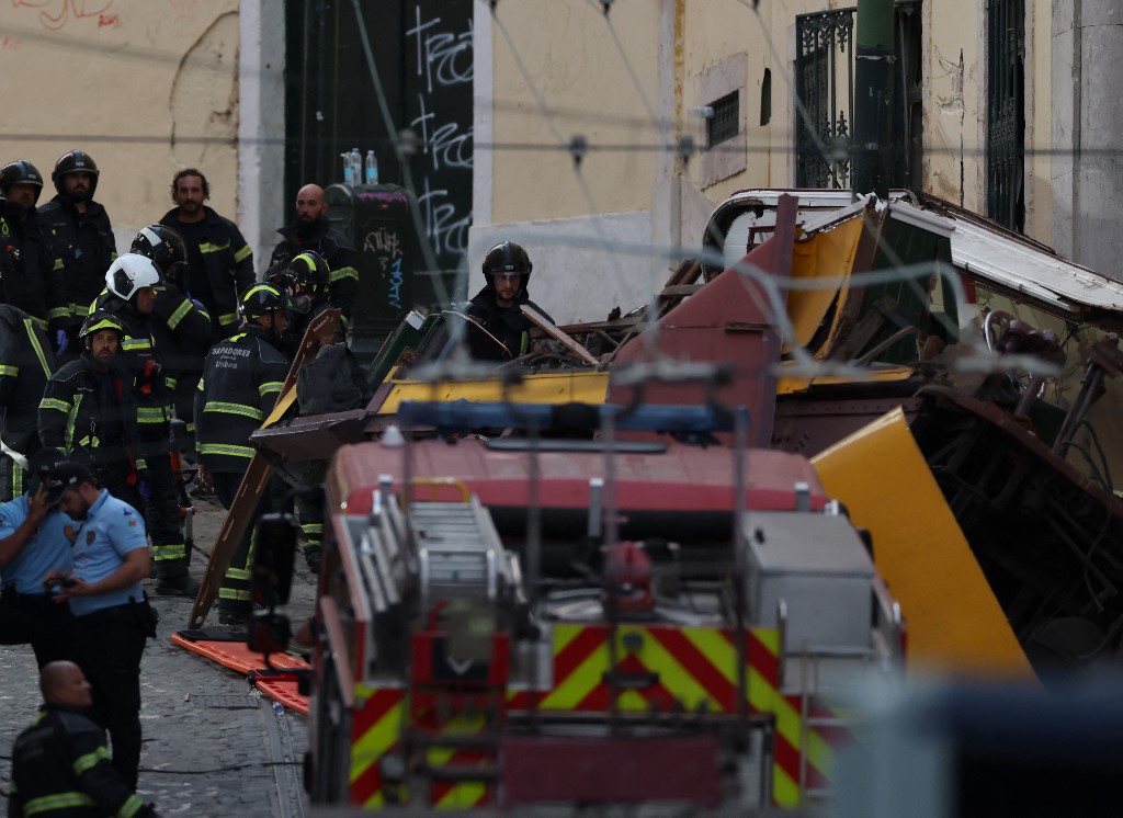 Police and firefighters work on the site of a funicular railway accident in Lisbon, on September 3, 2025. The accident of a funicular railway caused several dead and seriously injured in Lisbon, announced the Portugal's President of the Republic. (Photo by PATRICIA DE MELO MOREIRA / AFP)