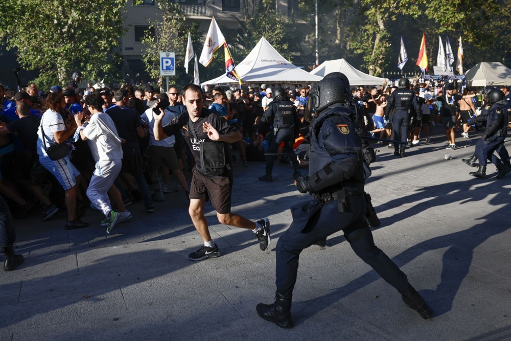 Members of the Spanish national police clash with supporters of Olympique de Marseille near the Santiago Bernabeu stadium ahead of the UEFA Champions League soccer match between Real Madrid and Olympique de Marseille in Madrid