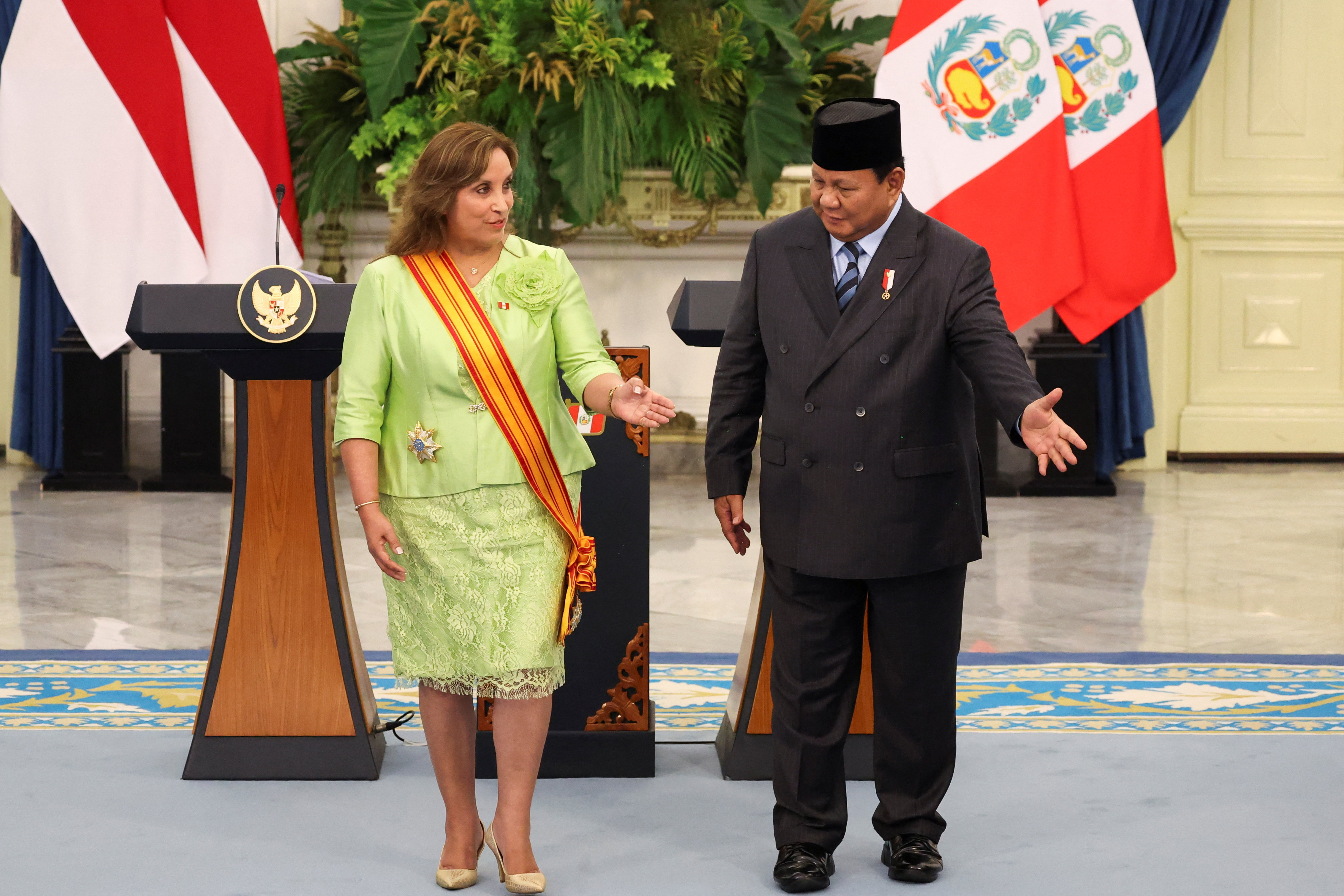 President Prabowo Subianto and President Dina Boluarte stand side by side on a stage in front of their countries' flags.