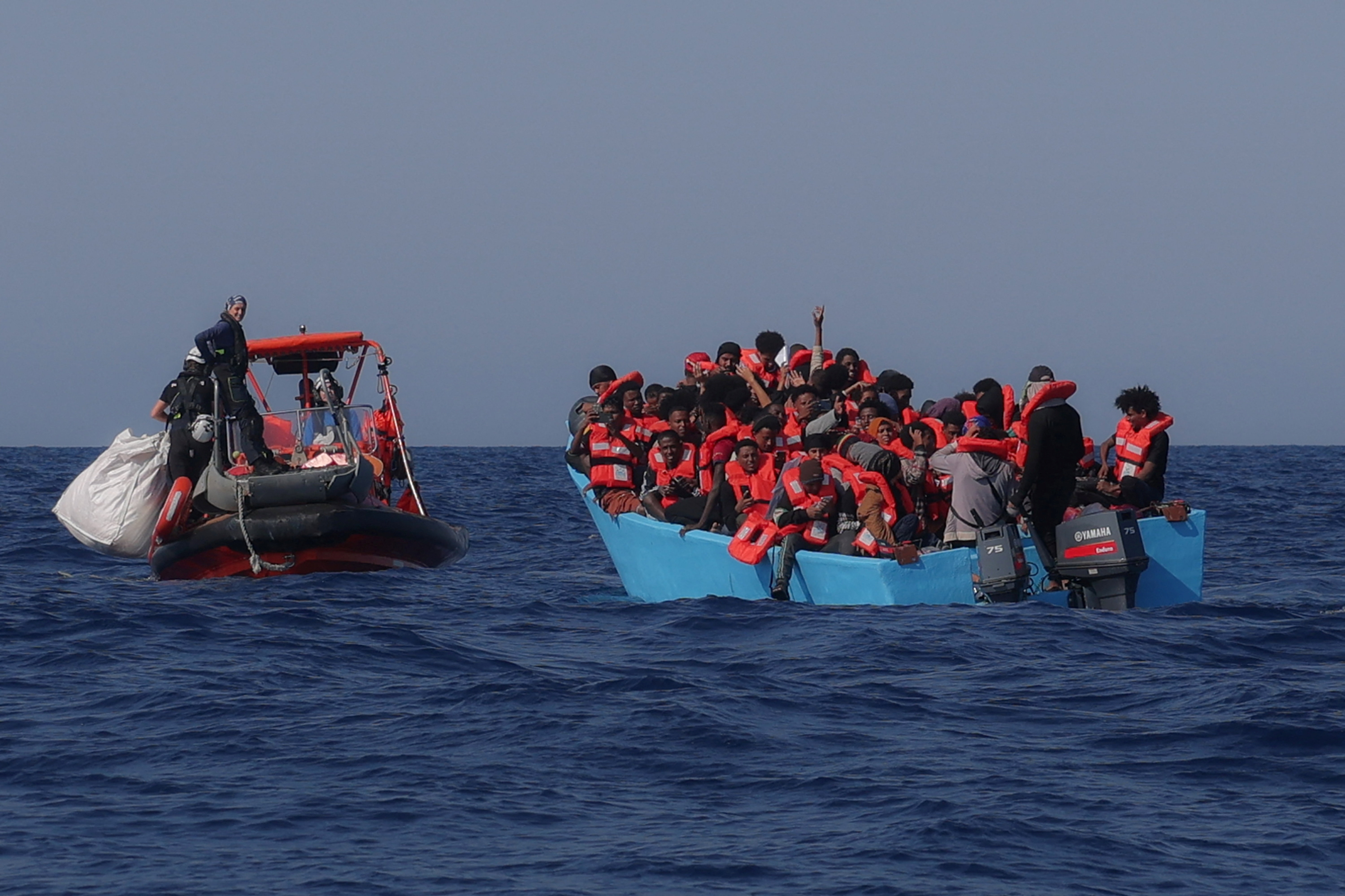 Refugees and asylum seekers on board an overcrowded boat are approached by the crew of the search and rescue ship Sea-Watch 5 in the central Mediterranean, off Libya
