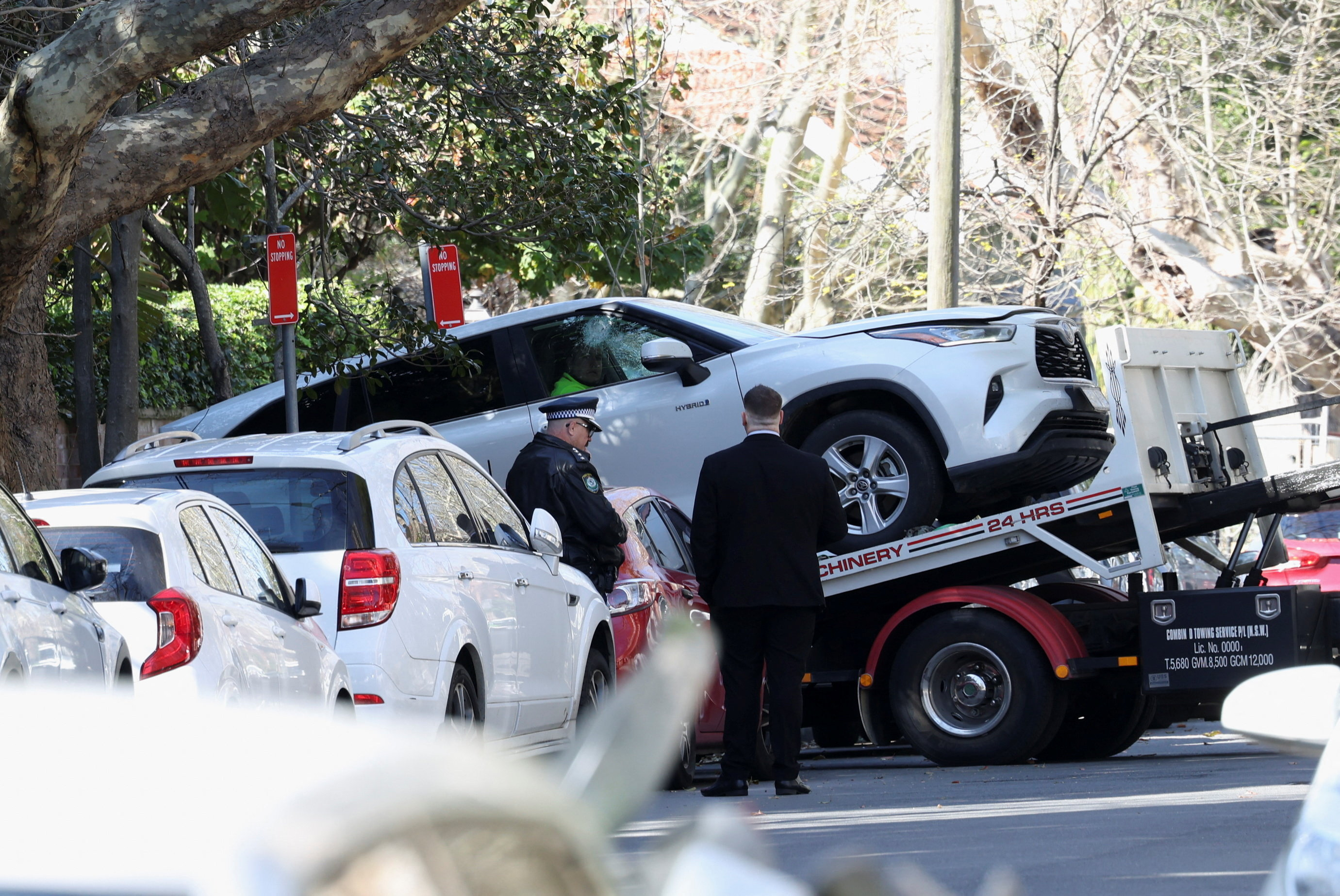 Police officers oversee the loading of a car with a smashed window onto a flatbed truck after it crashed into the Russian consulate in Sydney, Australia, September 1, 2025.
