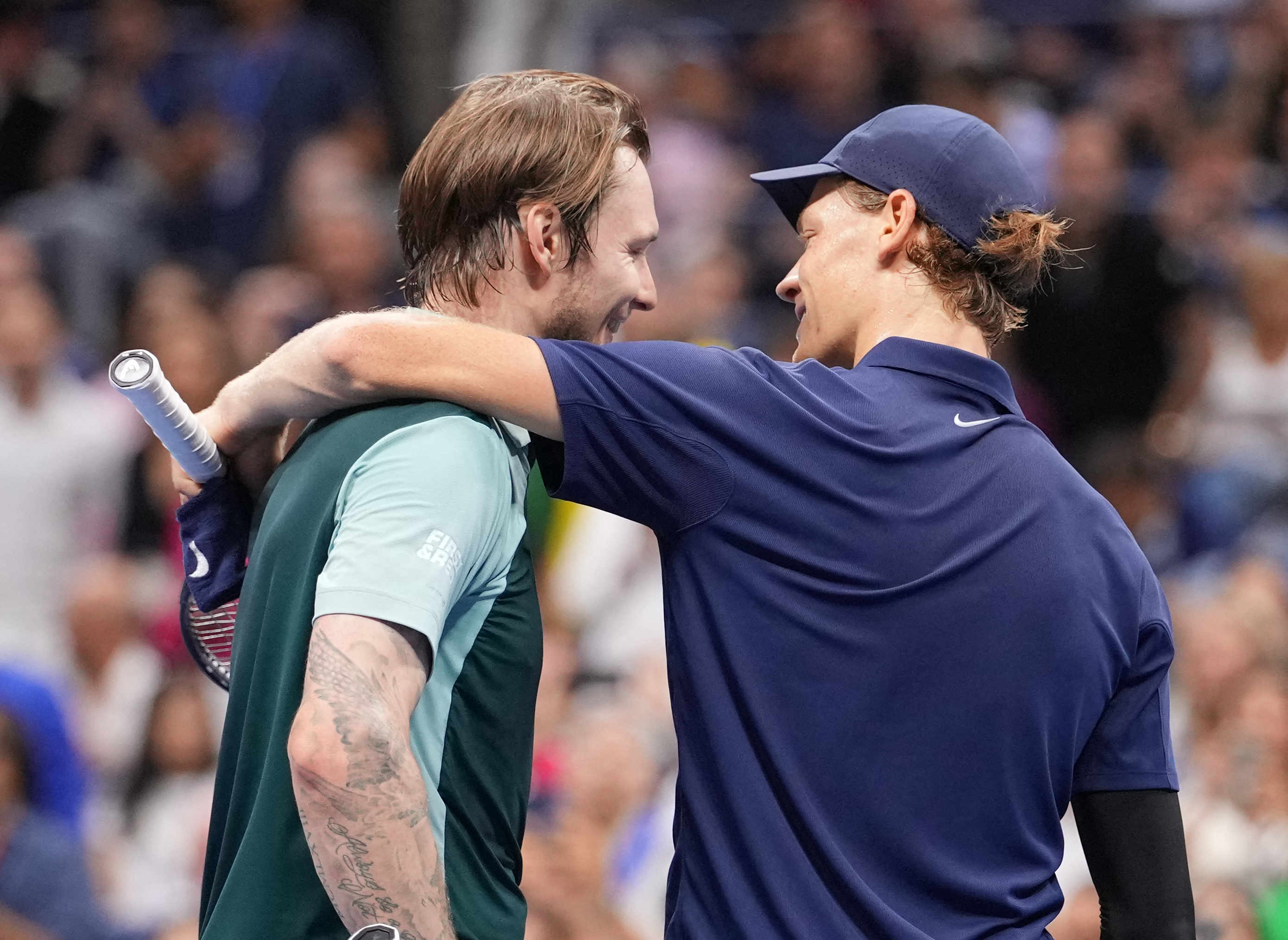 Jannik Sinner and Alexander Bublik embrace after match.