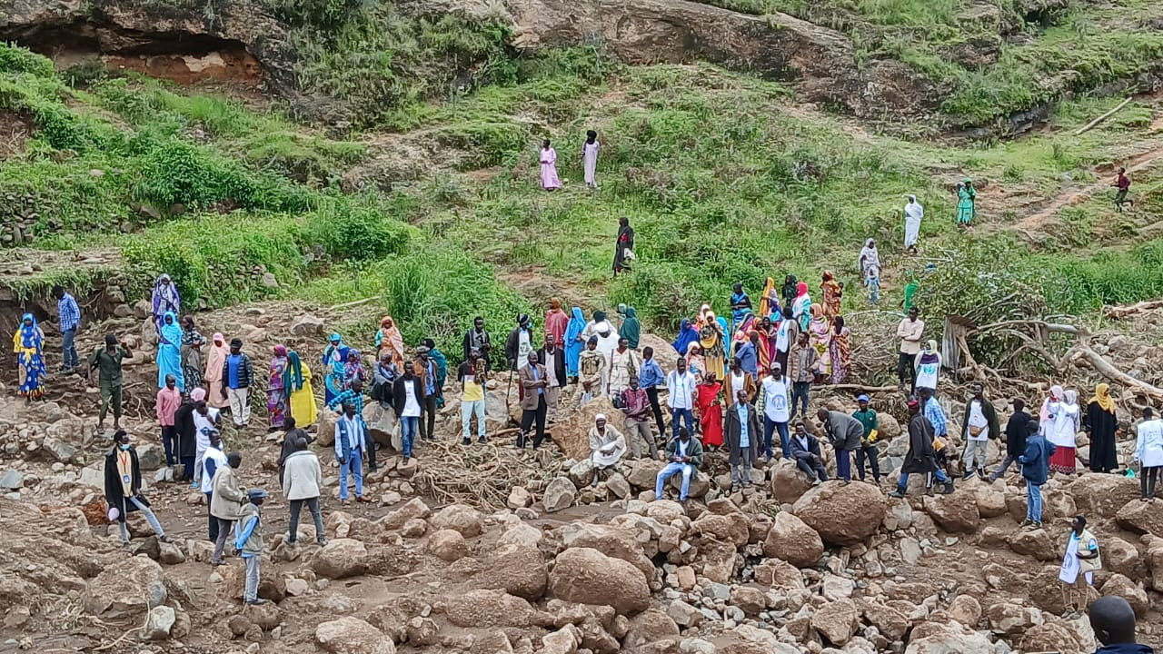 People gather as a Sudanese official announces recovery of 300 bodies after landslide destroyed Tarseen village, in Sudan, in this handout picture released September 4, 2025.