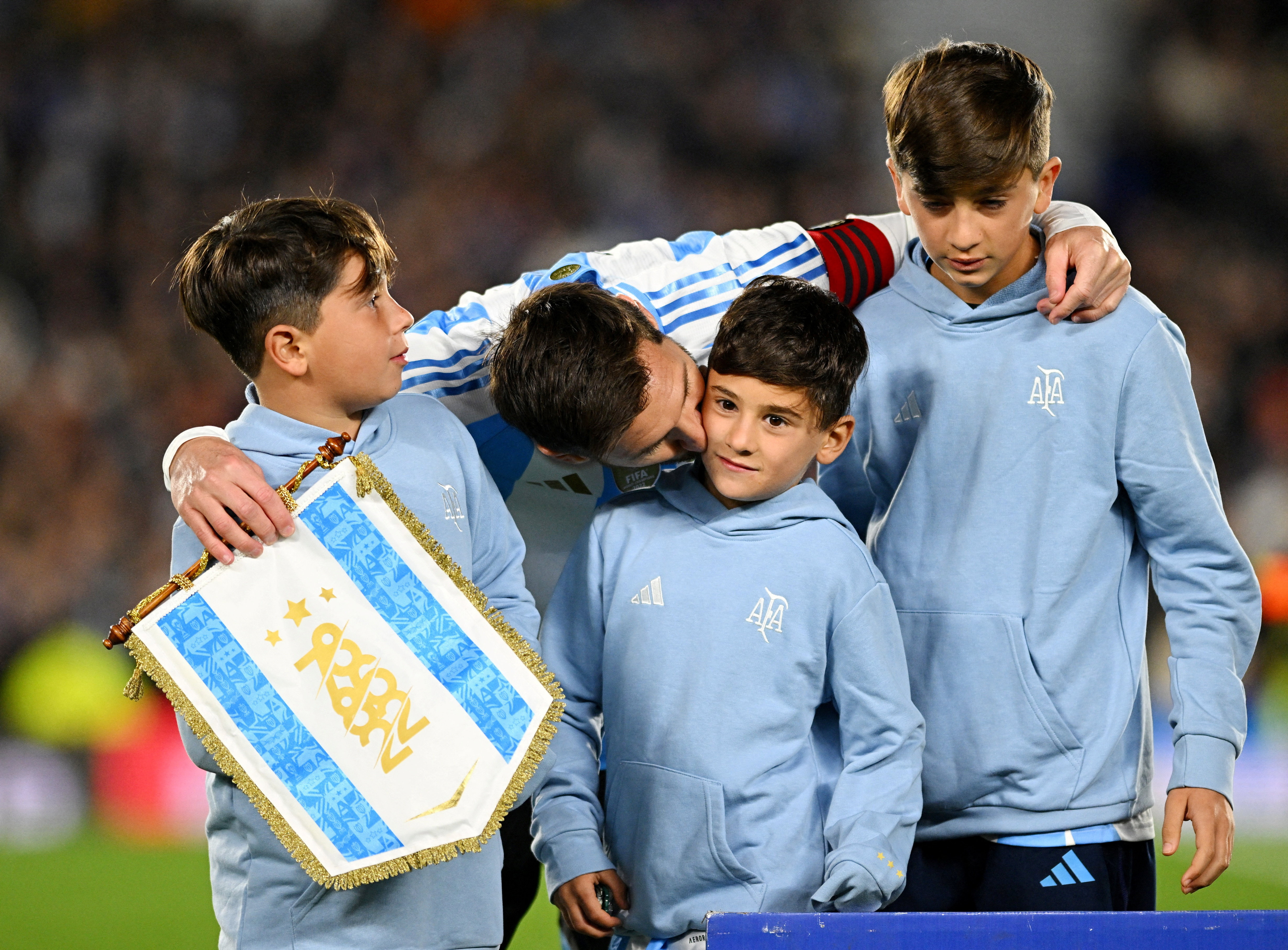 Argentina's Lionel Messi with his children on the pitch.