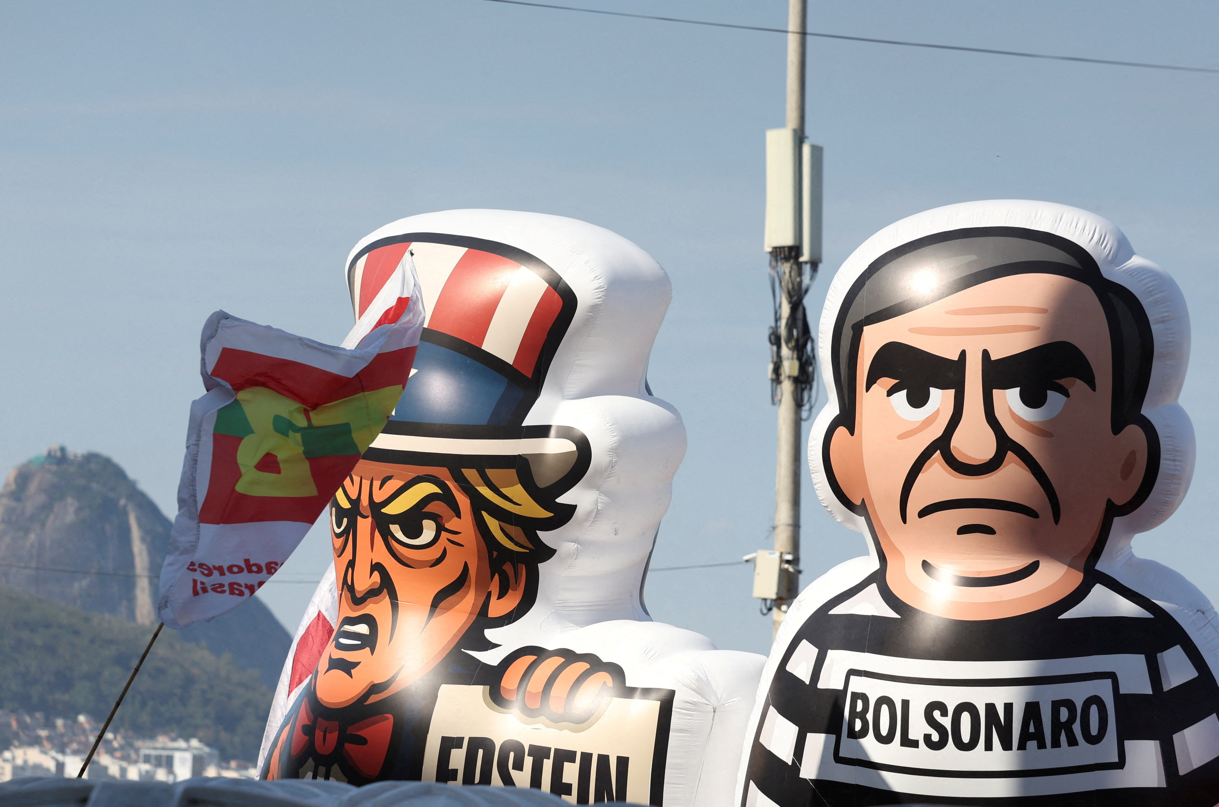 Inflatable figures depicting Brazil's former President Jair Bolsonaro and US President Donald Trump are seen during a protest on September 21 against a proposed amnesty bill that would change penalties for those convicted of plotting a coup in Rio de Janeiro, Brazil. On Monday, the US issued more sanctions [Pilar Olivares/Reuters]