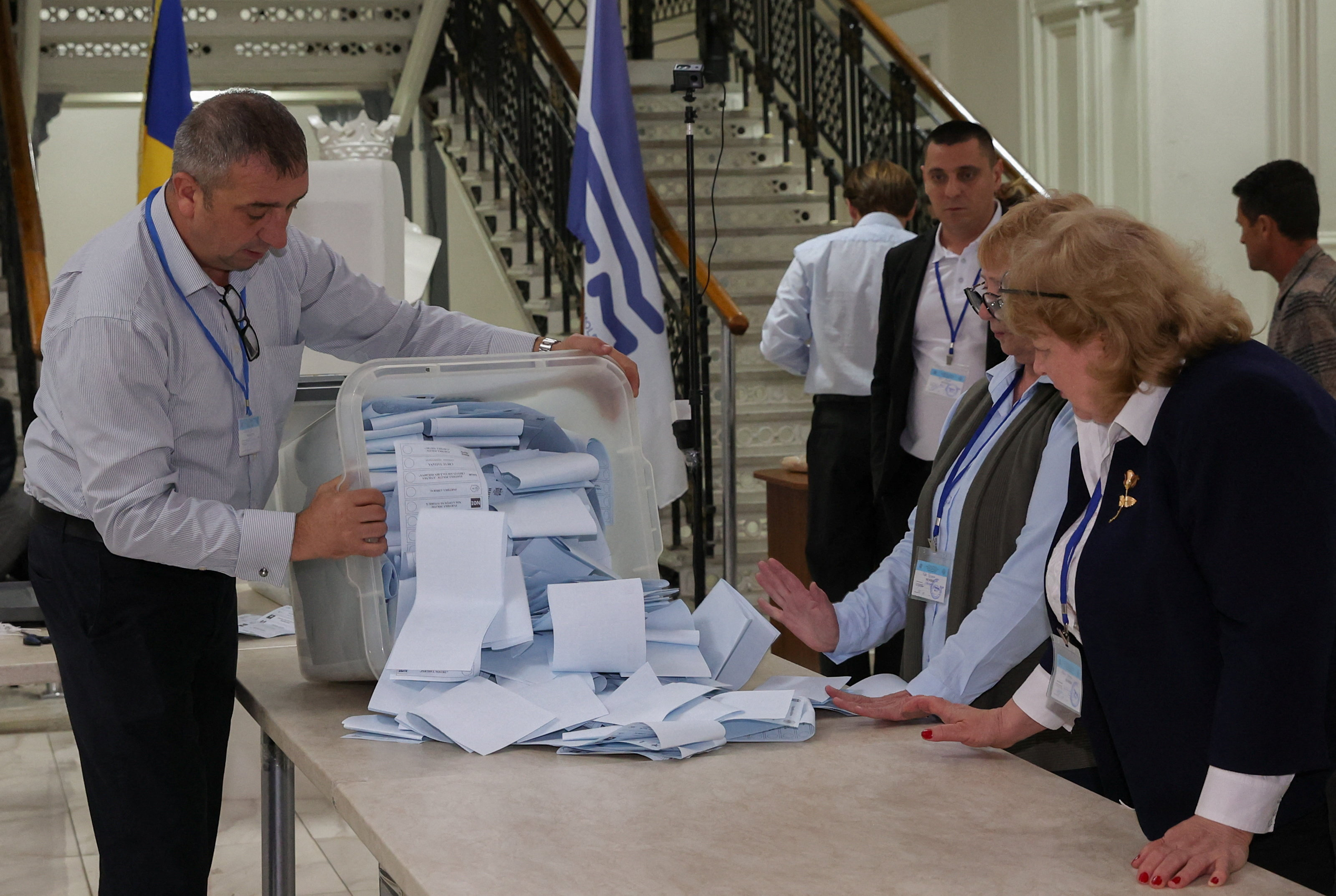 Members of an electoral commission empty a ballot box after polling stations closed in Moldova's parliamentary elections in Chisinau, Moldova