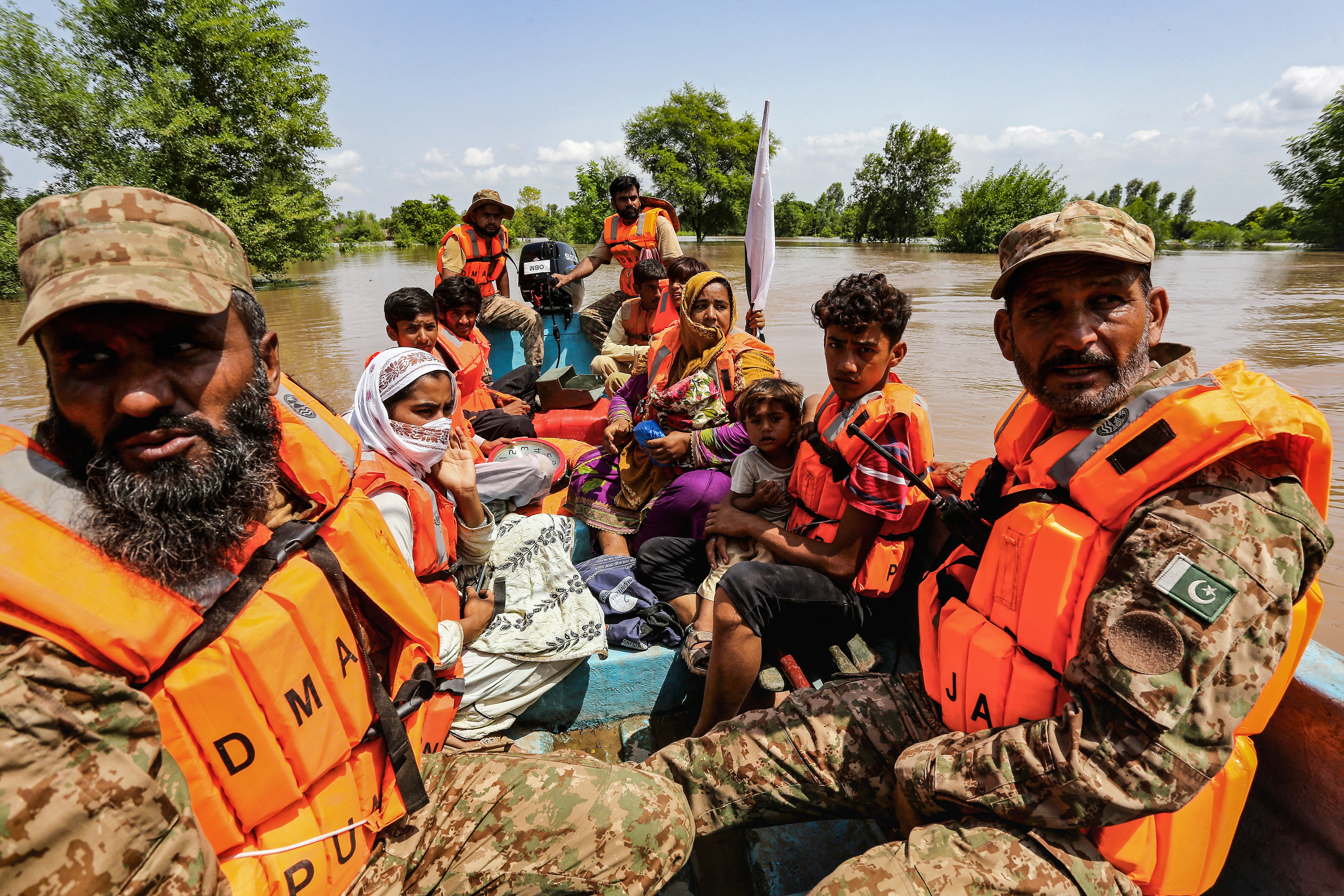 Pakistani soldiers ferry flood-affected villagers evacuated by boat from the Muzaffargarh district in Punjab province on September 3, 2025.